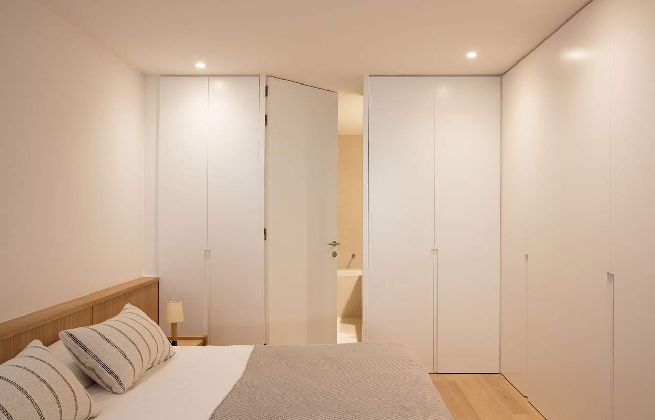 Dormitorio en tonos blancos y neutros de estilo minimalista.