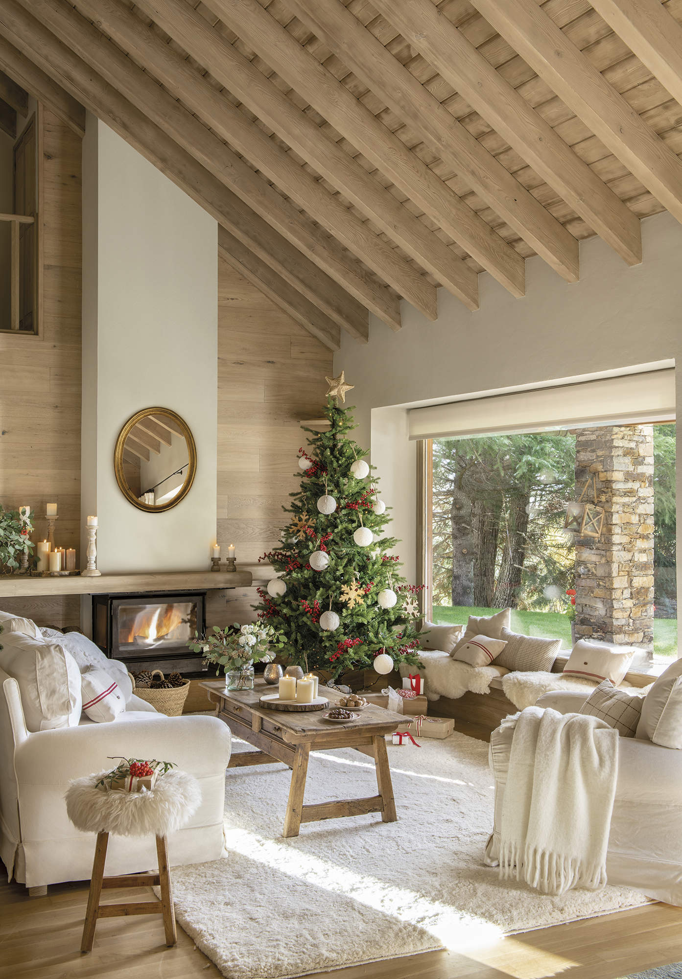 Salón r��stico con vigas, sofás blancos, alfombra, chimenea y árbol de Navidad