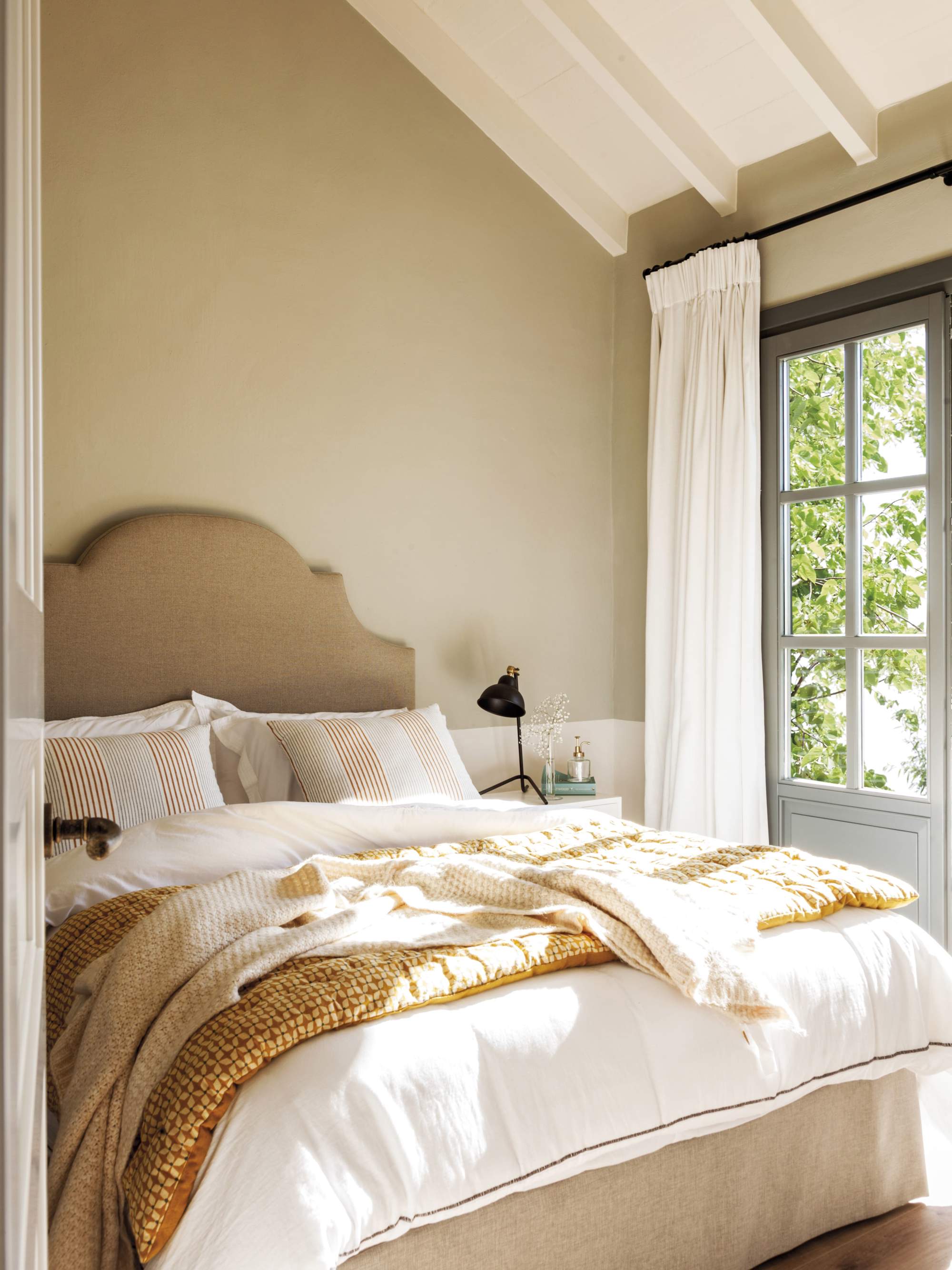 Dormitorio con ropa de cama en tonos beige y ocre.