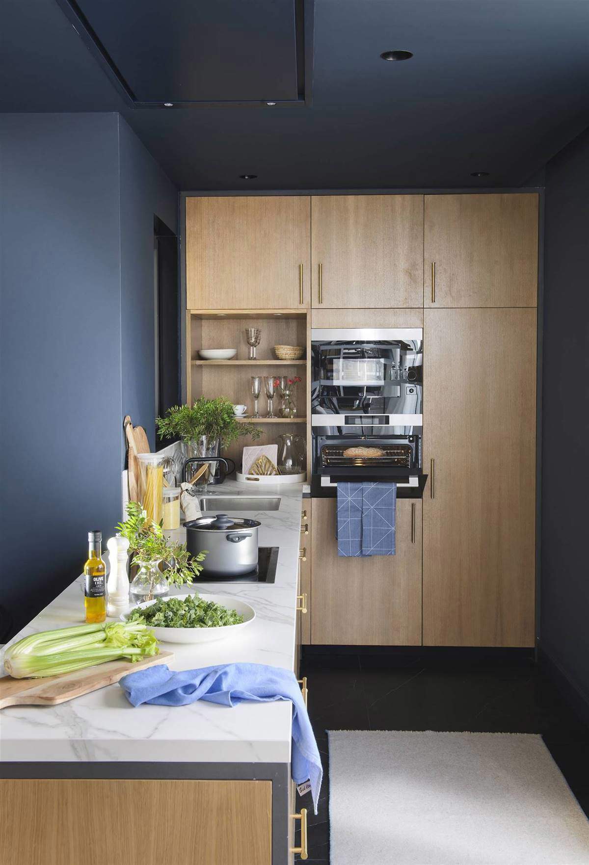 Cocina en L con paredes pintadas en color azul.
