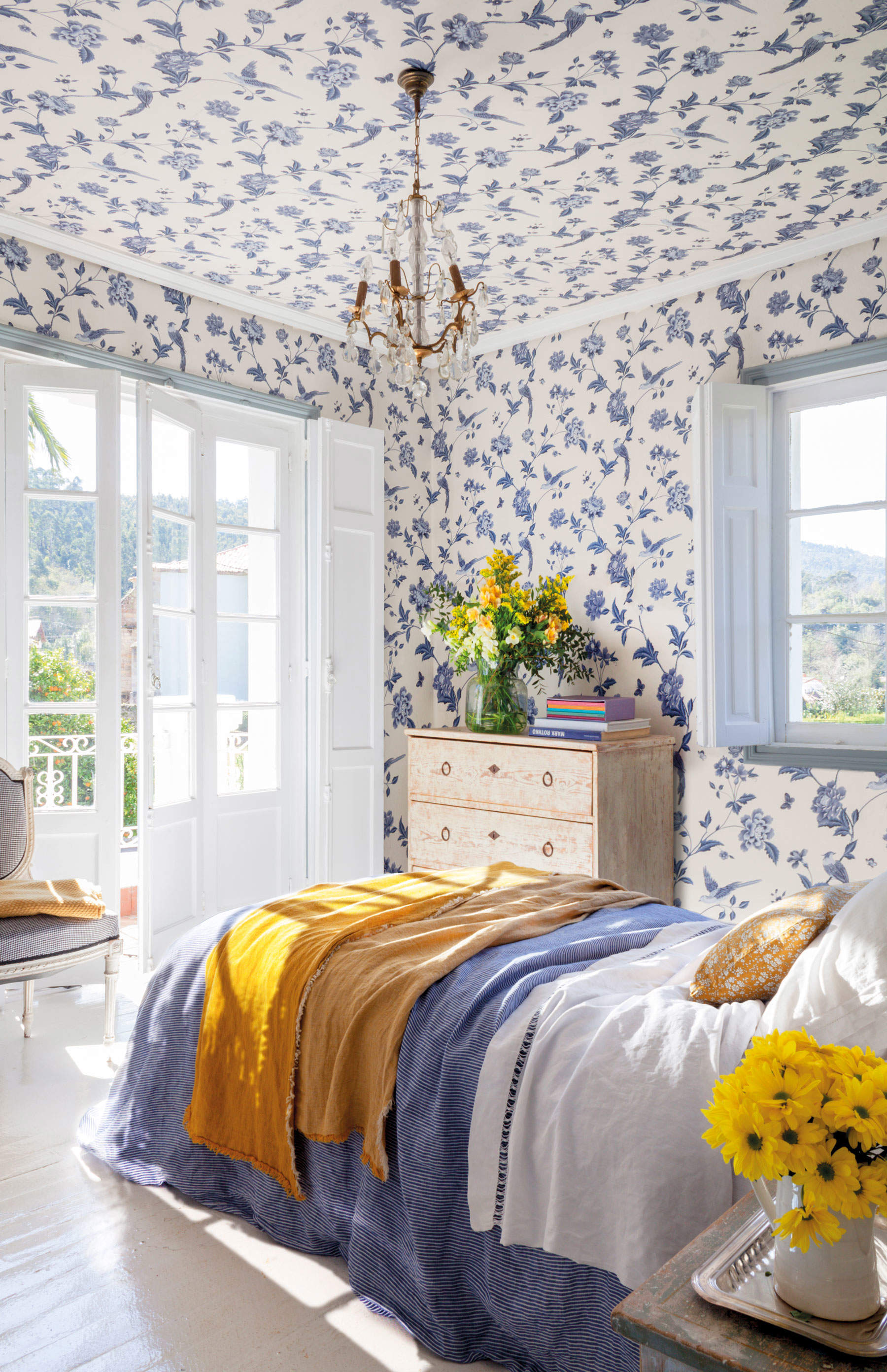 Dormitorio con papel pintado en paredes y techos azul.