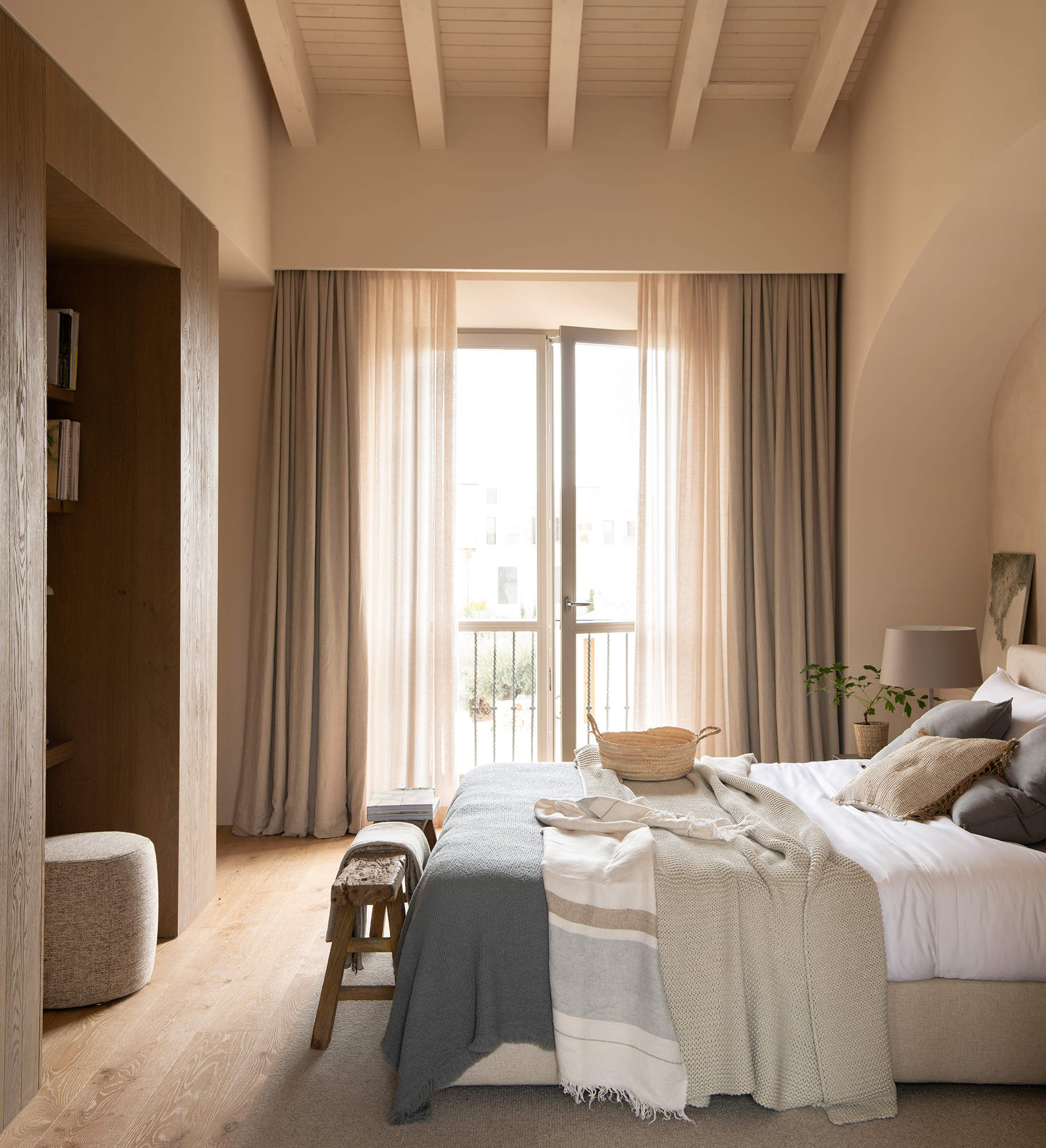 Dormitorio con visillos y cortinas de lino.