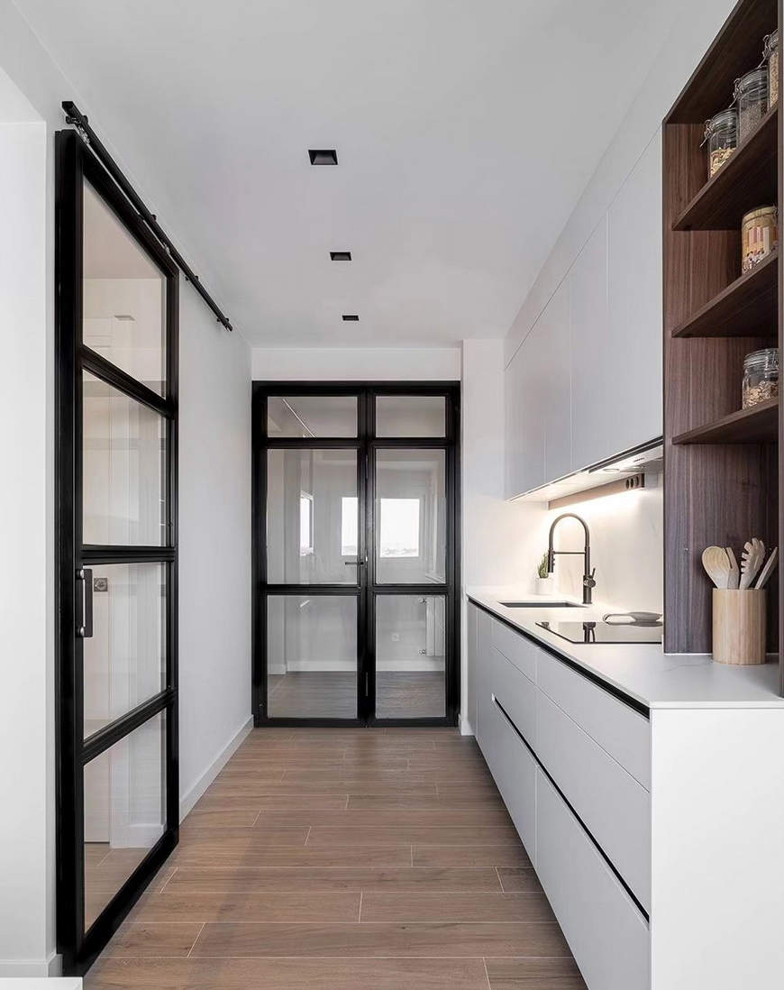 Cocina moderna con muebles en blanco y madera con puertas de acceso de cristal