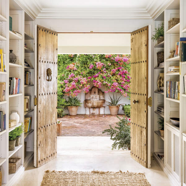 Esta preciosa casa en Marbella está llena de ideas originales: un recibidor con librerías, chimenea y dos cómodas en el salón, el comedor en el porche...