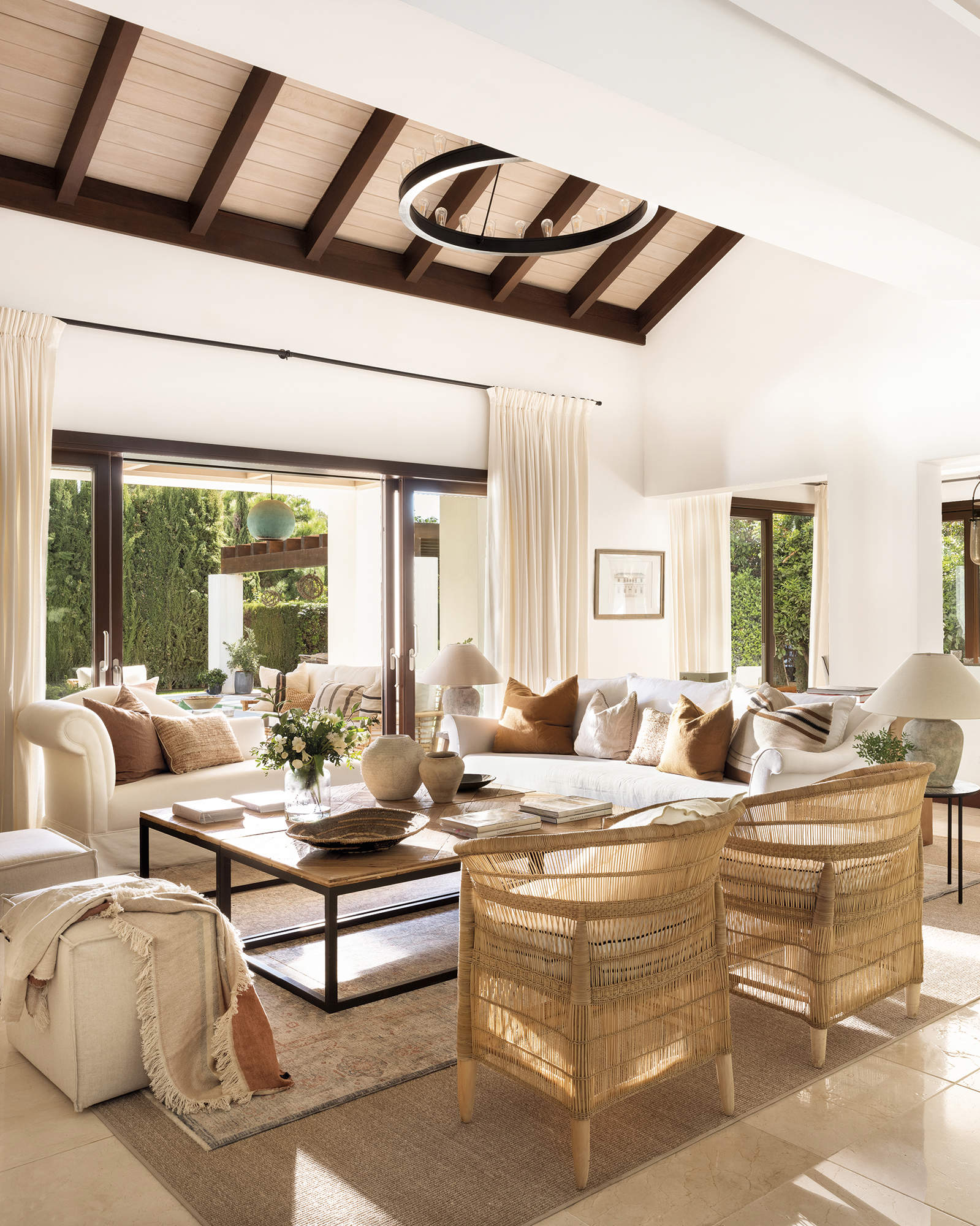 Salón elegante con sofá blanco, chaise longue, butacas de fibras y cojines terracota 