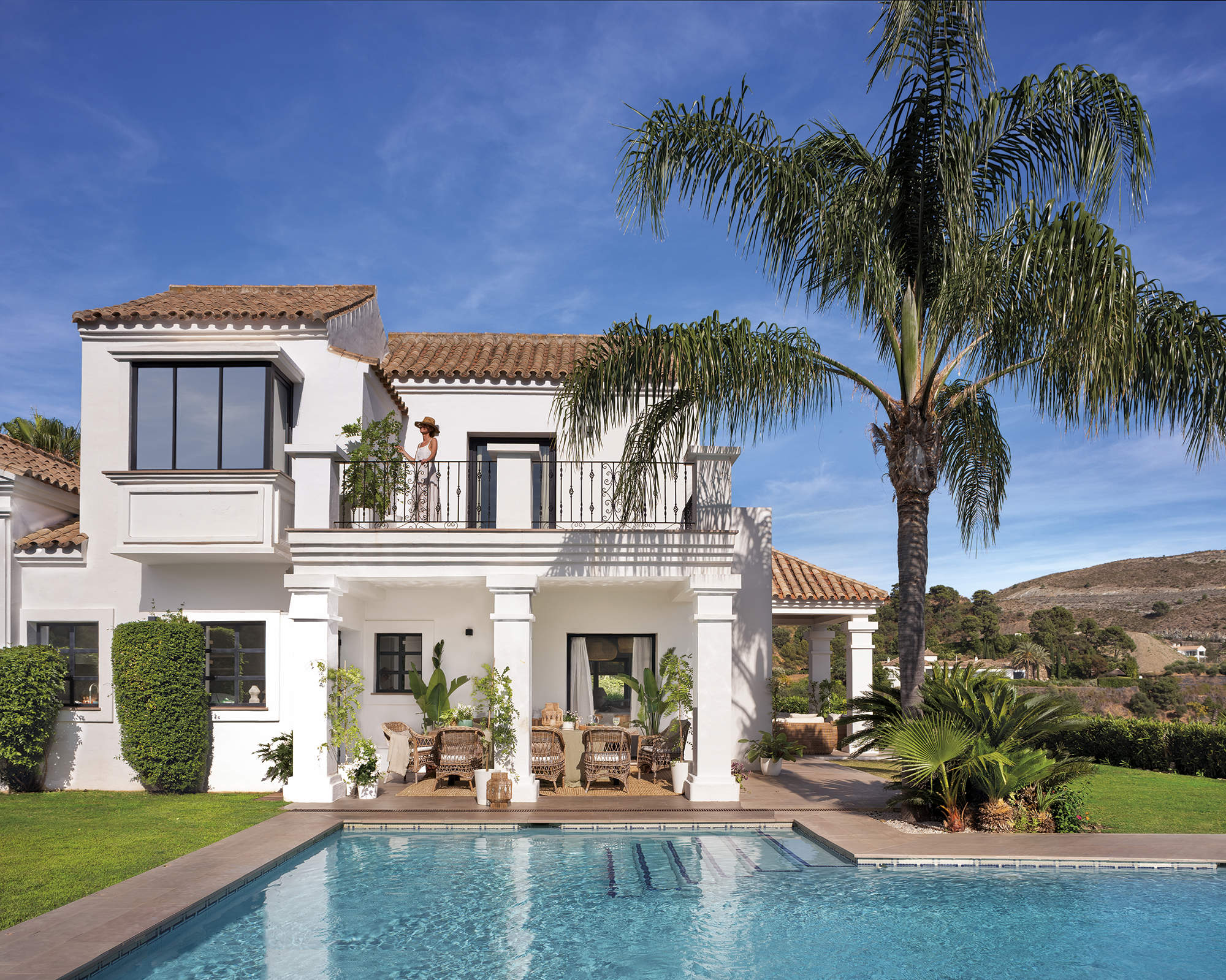 Fachada interior de casa soleada blanca con piscina