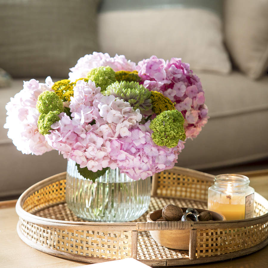 Mesa de centro con arreglo floral con hortensias rosas y verdes