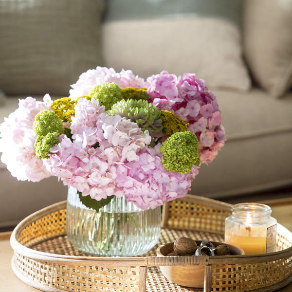 Mesa de centro con arreglo floral con hortensias rosas y verdes