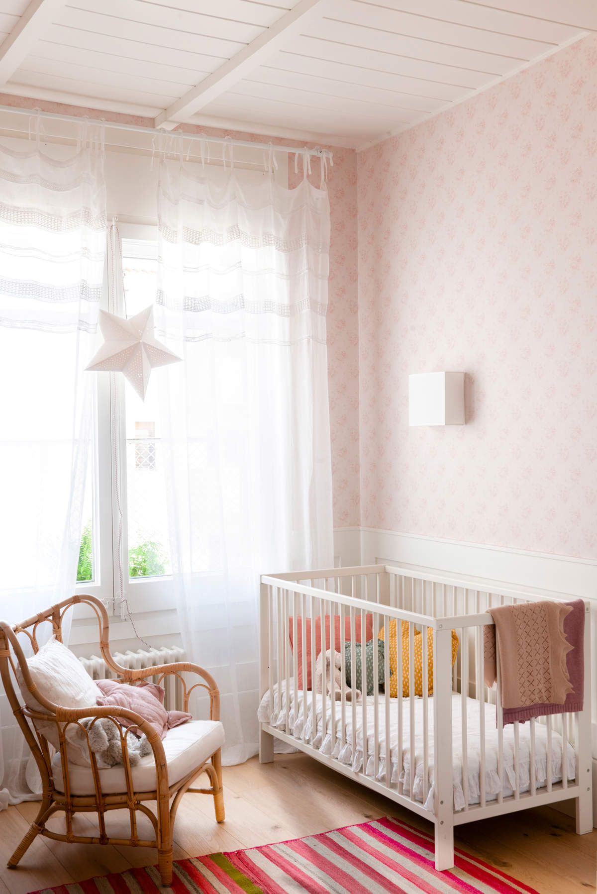 Habitación infantil decorada en blanco y rosa.
