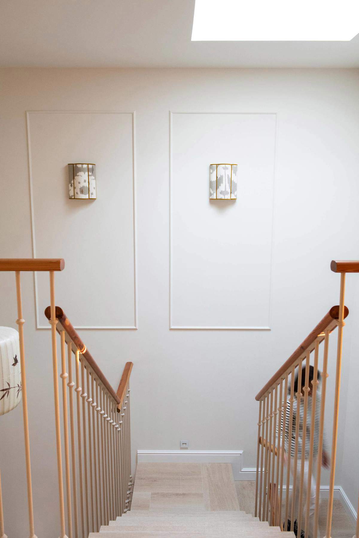 Descansillo de escalera decorado con apliques y molduras en la pared