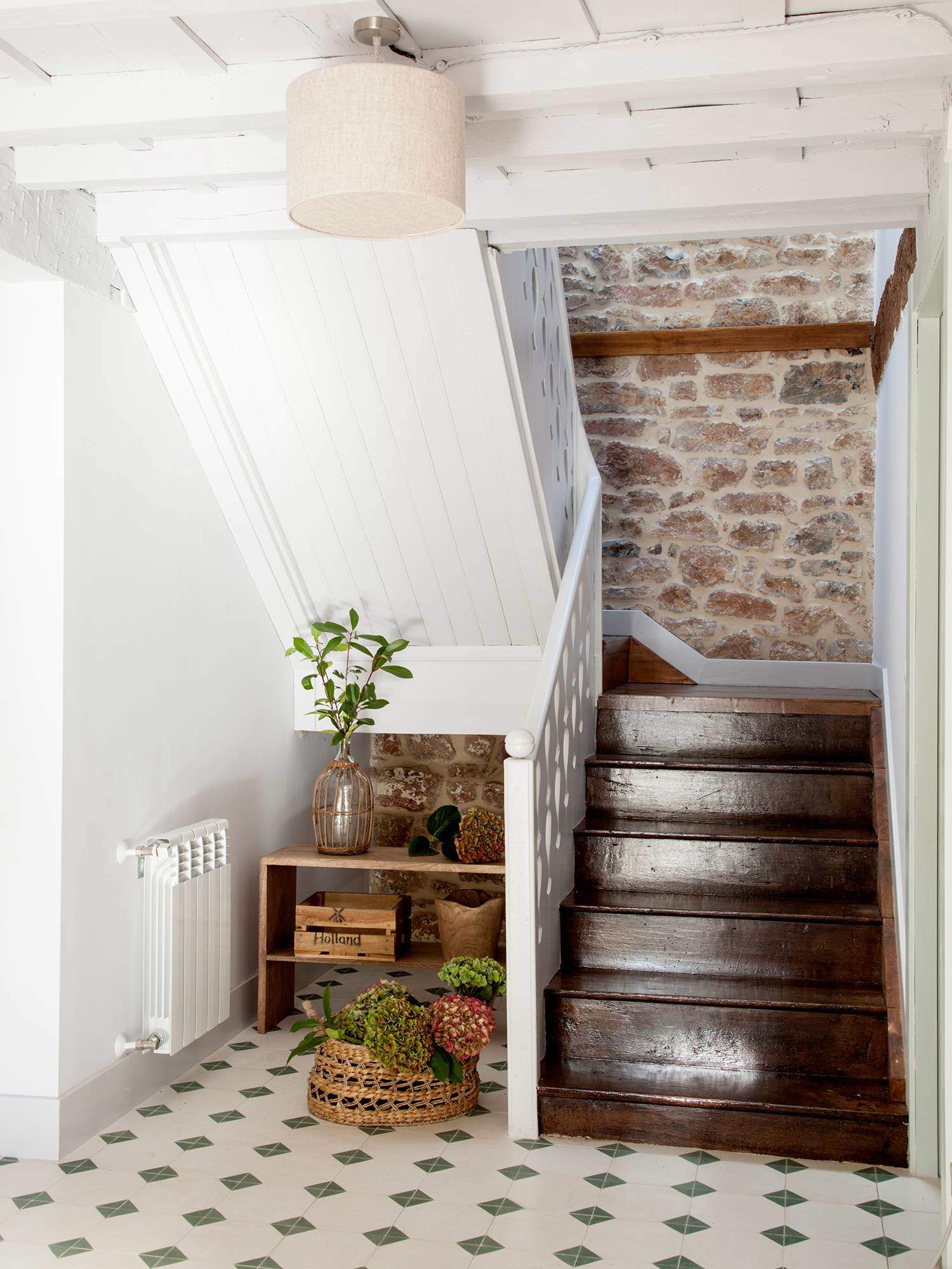 Escalera de madera oscura con pared de piedra