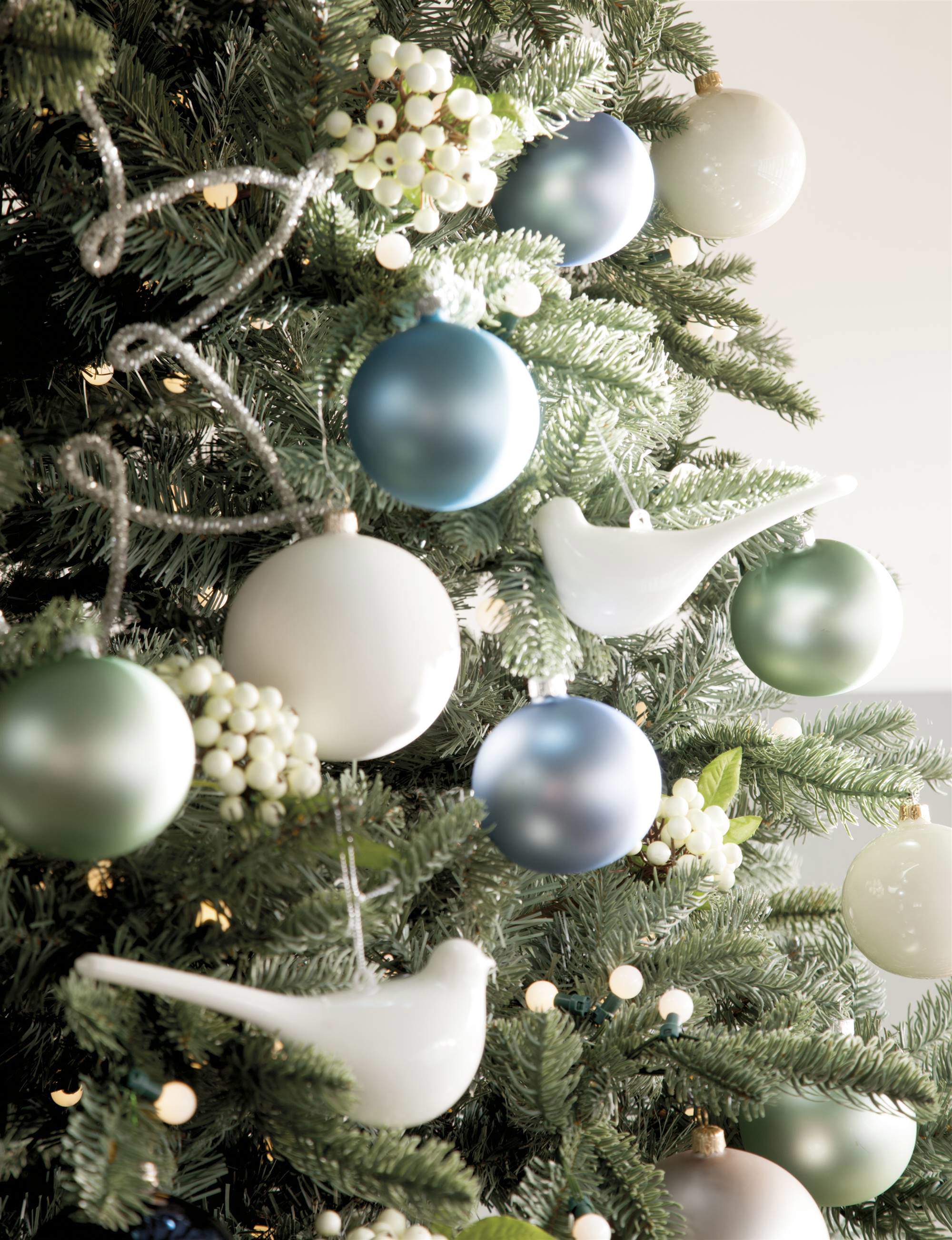 Bolas y figuras navideñas en tonos blancos, azules y verdes.