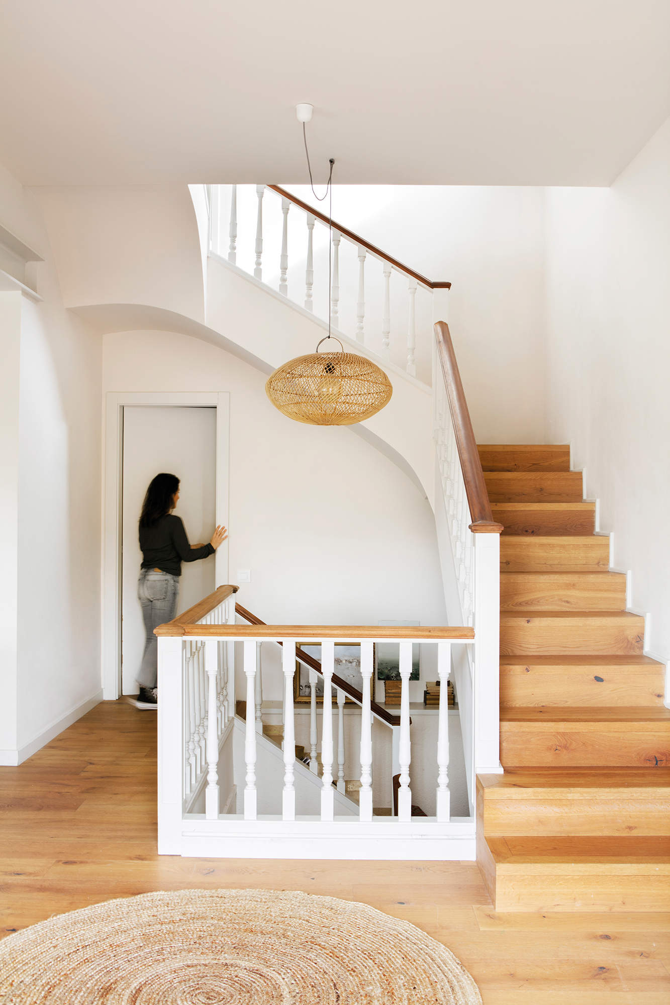 Zona de escalera decorada con lámpara colgante y alfombra