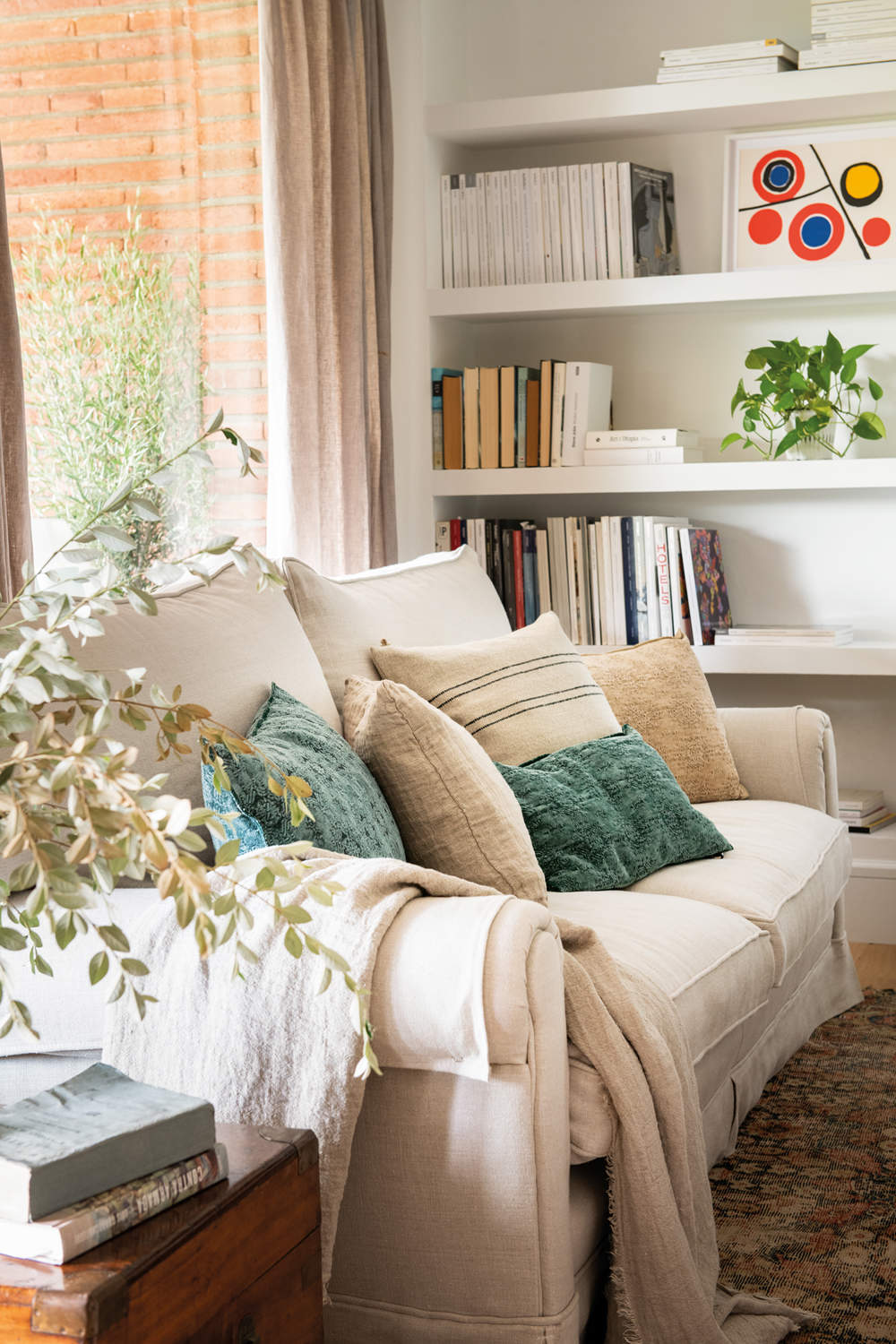 Sofá blanco en salón rústico con librería de obra