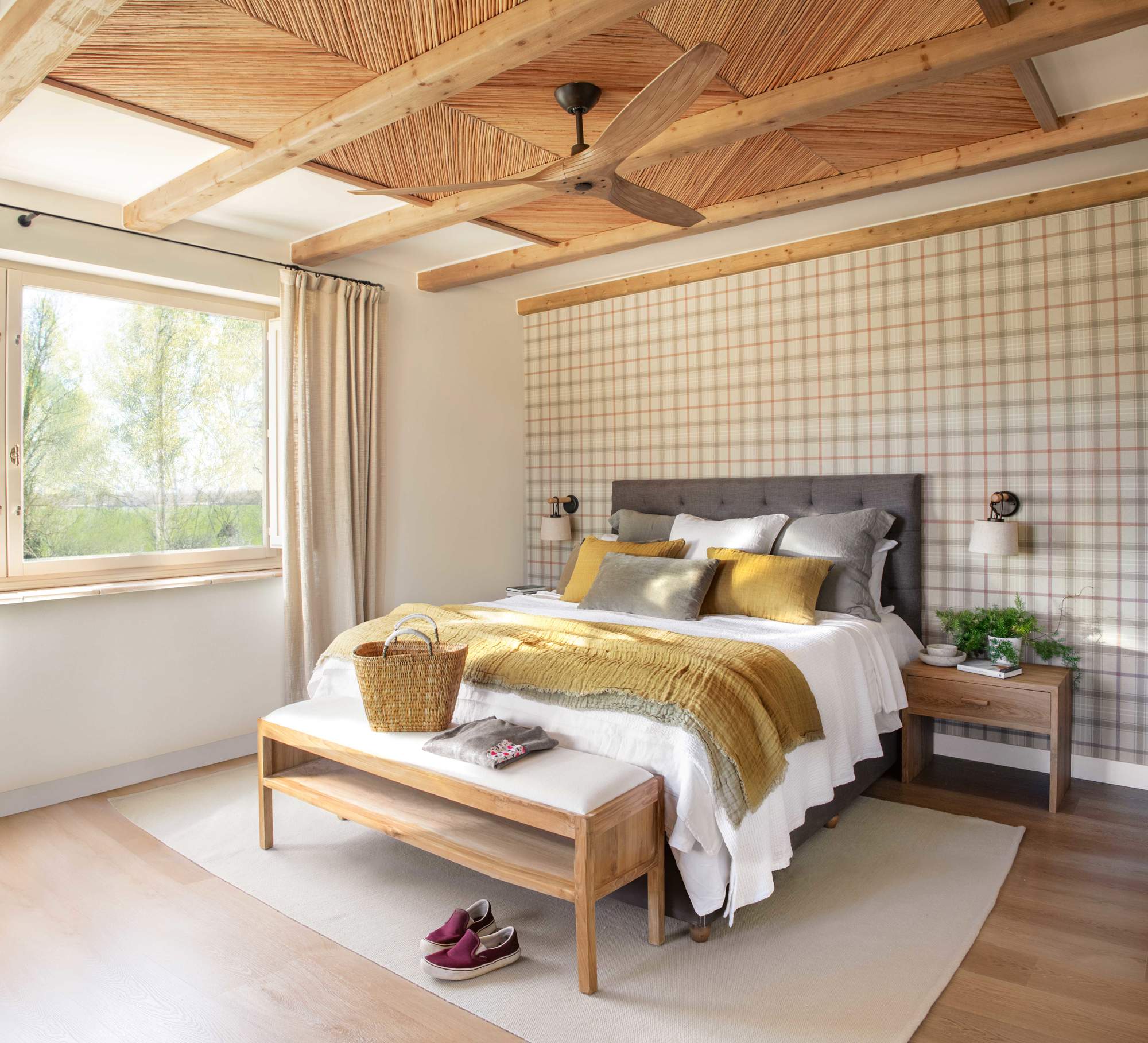 Dormitorio con papel pintado de cuadros, techo con vigas y cañizo y cabecero tapizado