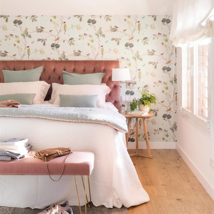 Dormitorio con cabecero en capitoné rosa y papel pintado botánico