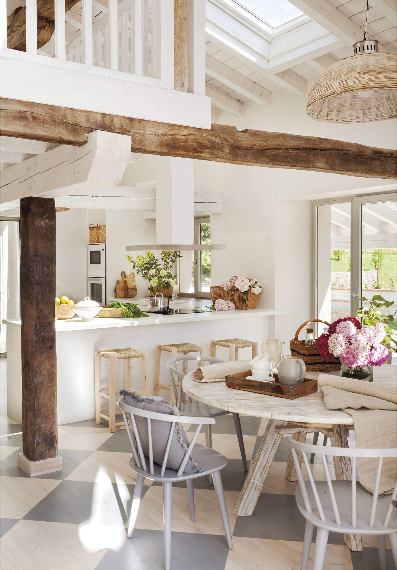 Cocina con vigas de madera natural a la vista, muebles de estilo rústico, y techos abovedados en blanco.