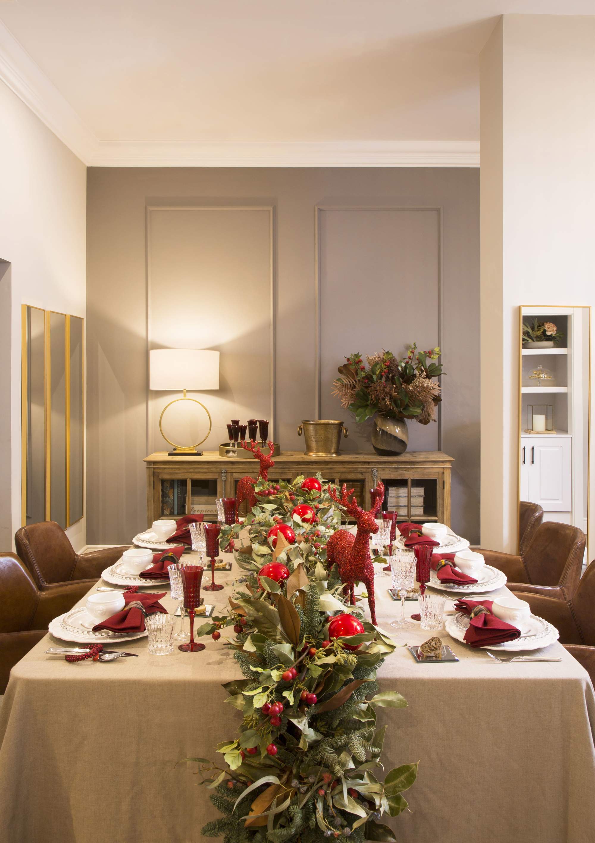 Mesa navideña con adornos en rojo y arreglos florales