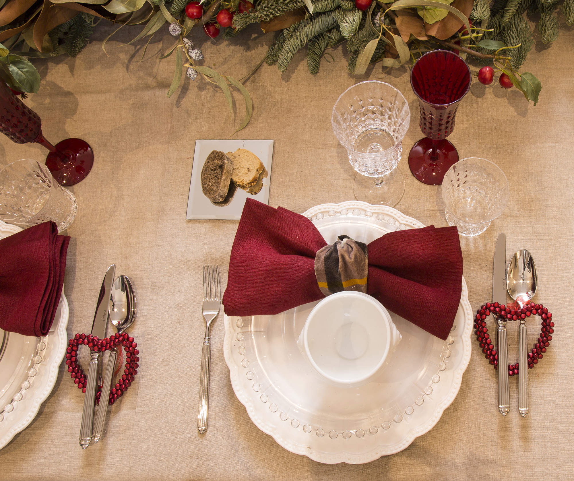 Mesa navideña con adornos en rojo y arreglos florales