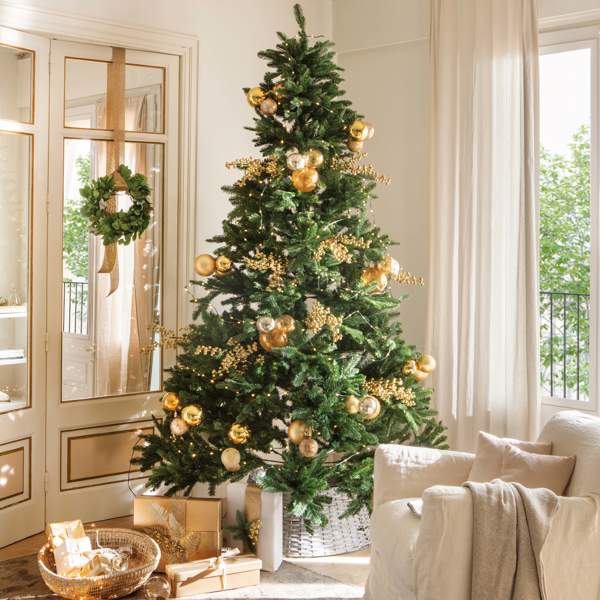Árbol de Navidad con adornos dorados y corona en la puerta