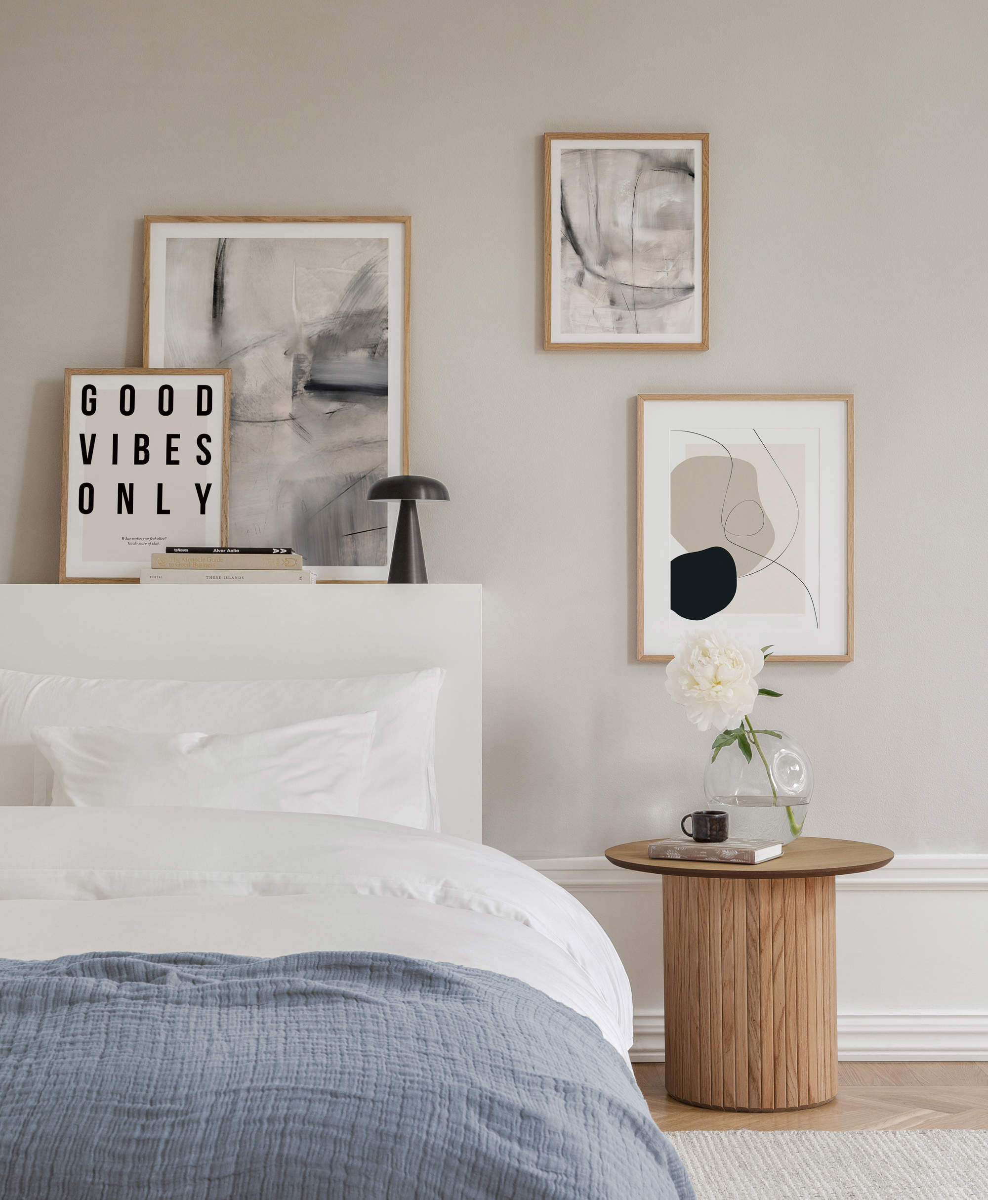 Dormitorio decorado con láminas abstractas en tonos crudos.