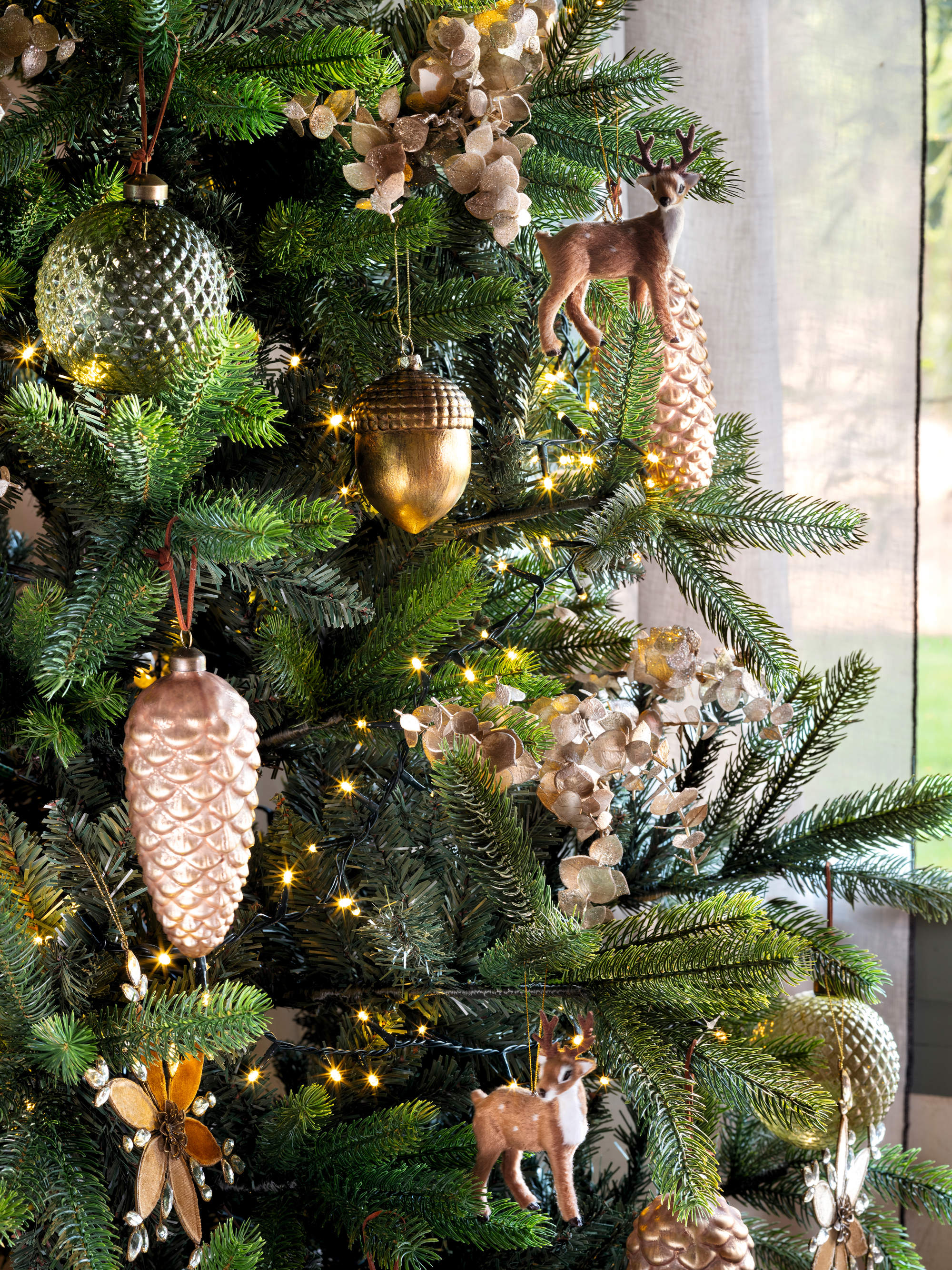 Árbol de Navidad con adornos en forma de piñas.