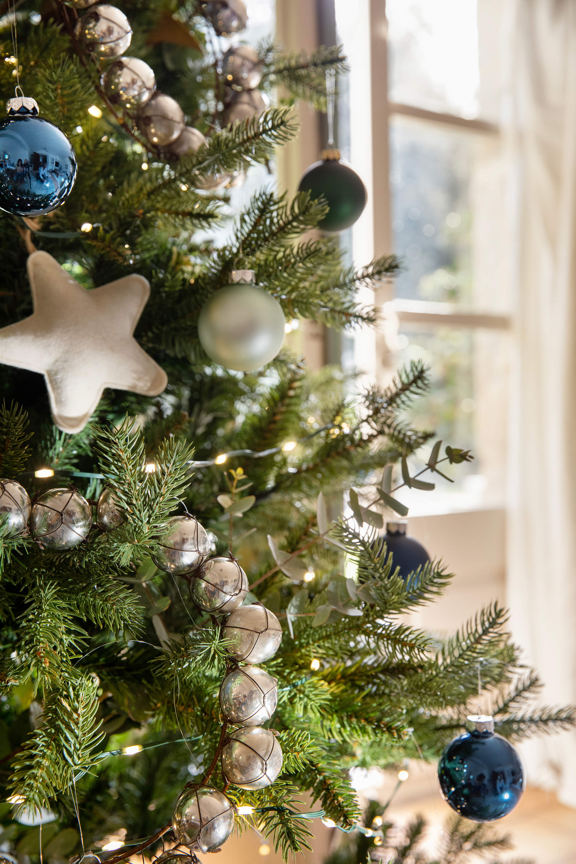 Árbol de Navidad decorado en tonos plateados y azules.