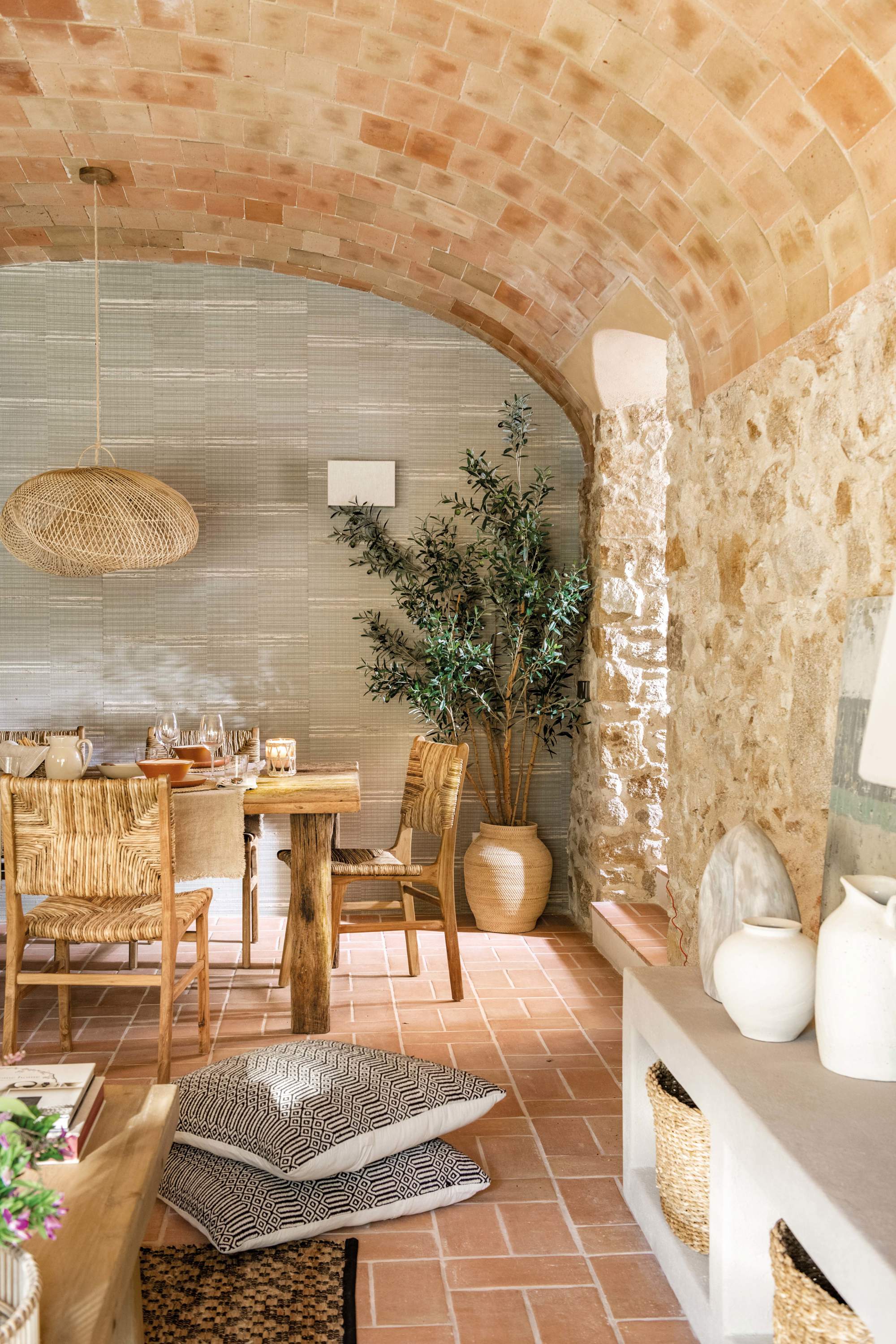 Salón con comedor empapelado, paredes de piedra y toba catalana