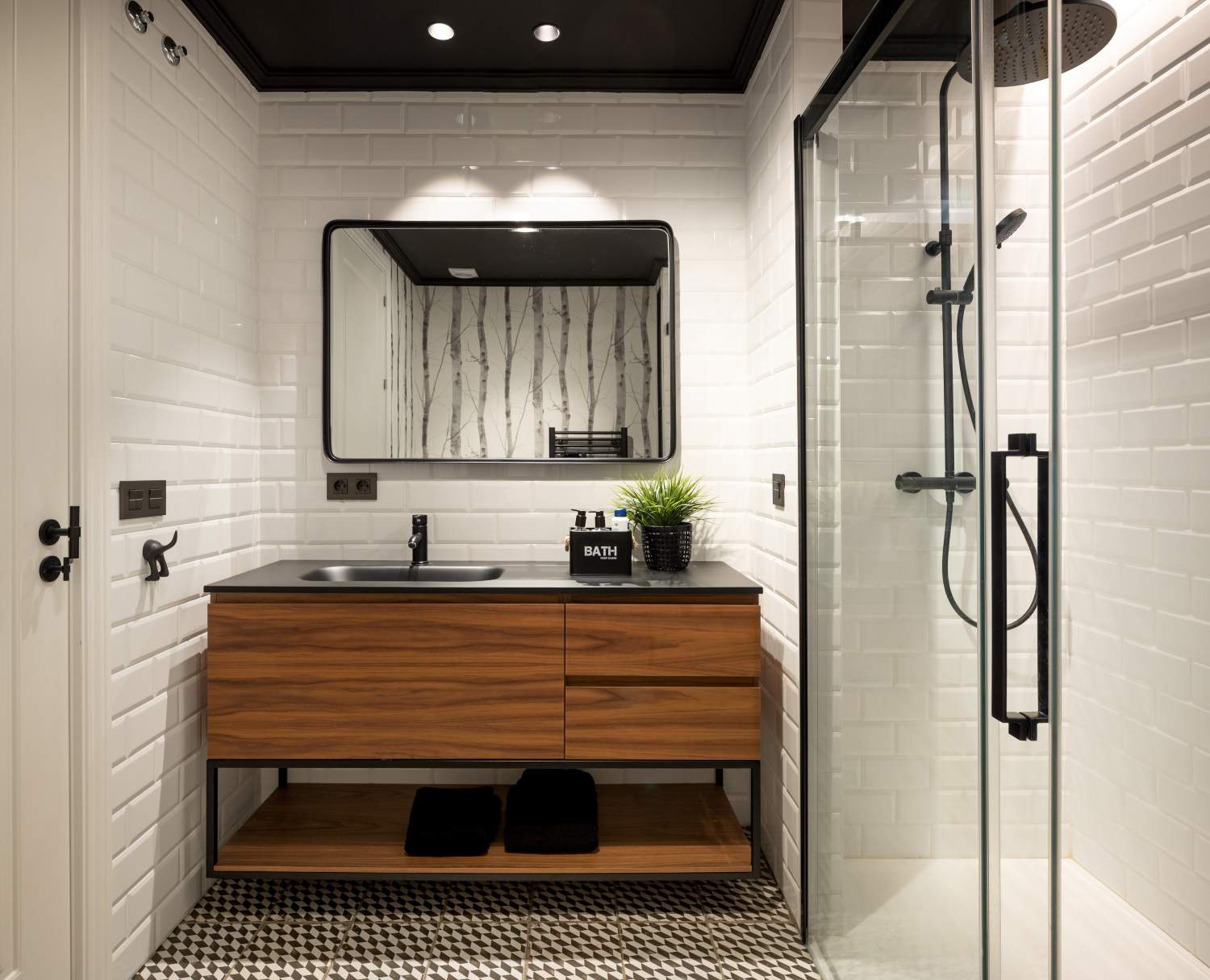 Un baño privado con ducha y lavabo con encimera de mármol negro.