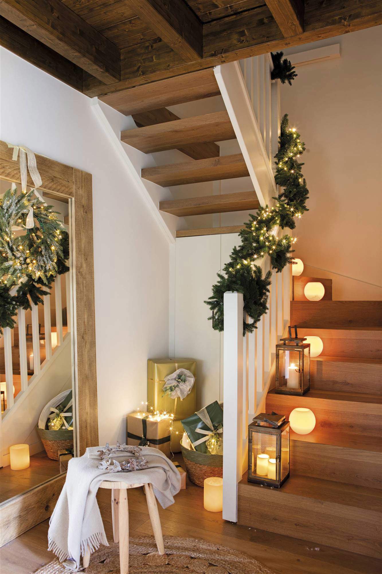 Escalera de recibidor decorada con velas y portavelas.