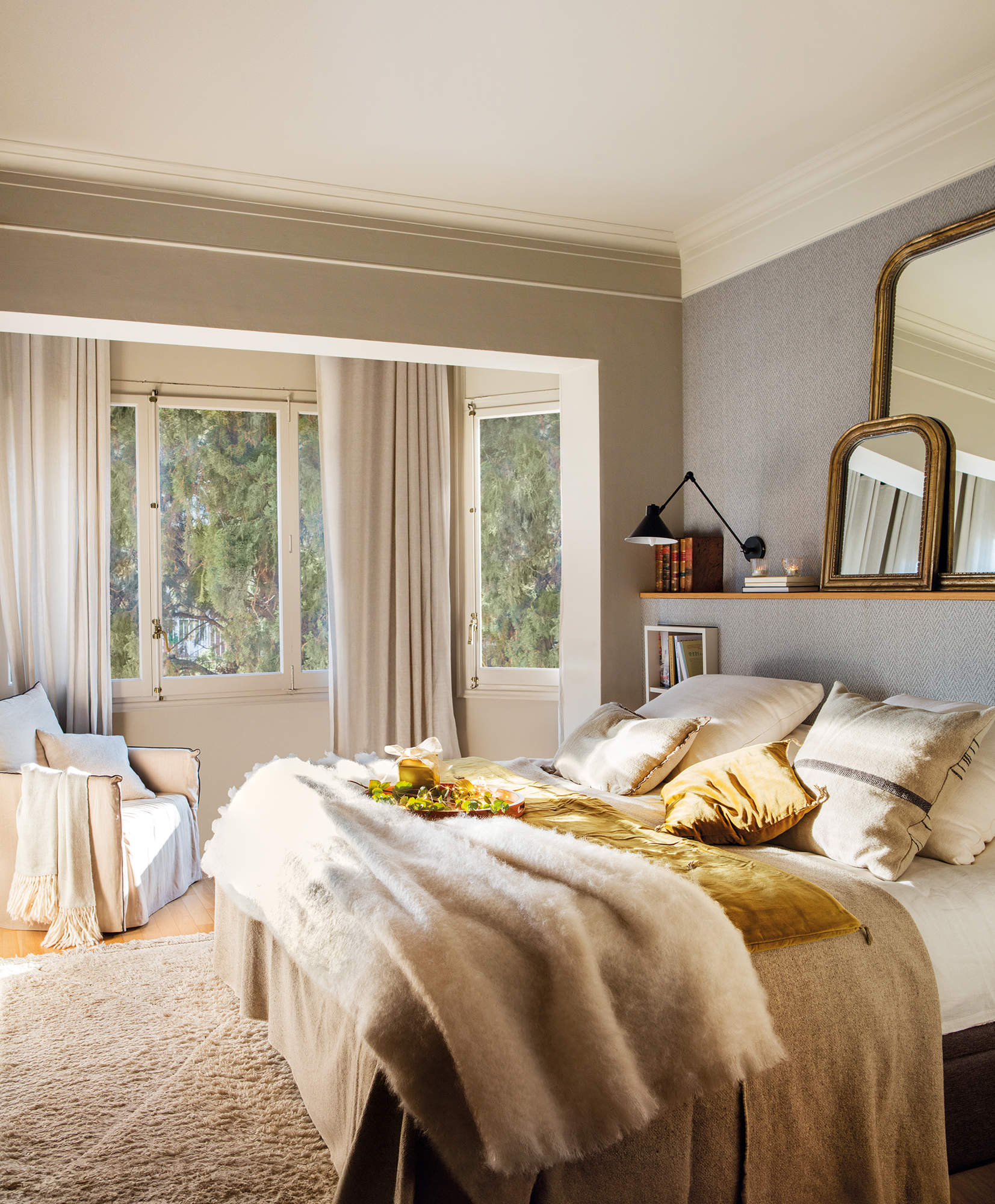 Dormitorio principal con textiles cálidos, decorado en tonos neutros y con pinceladas de dorado.