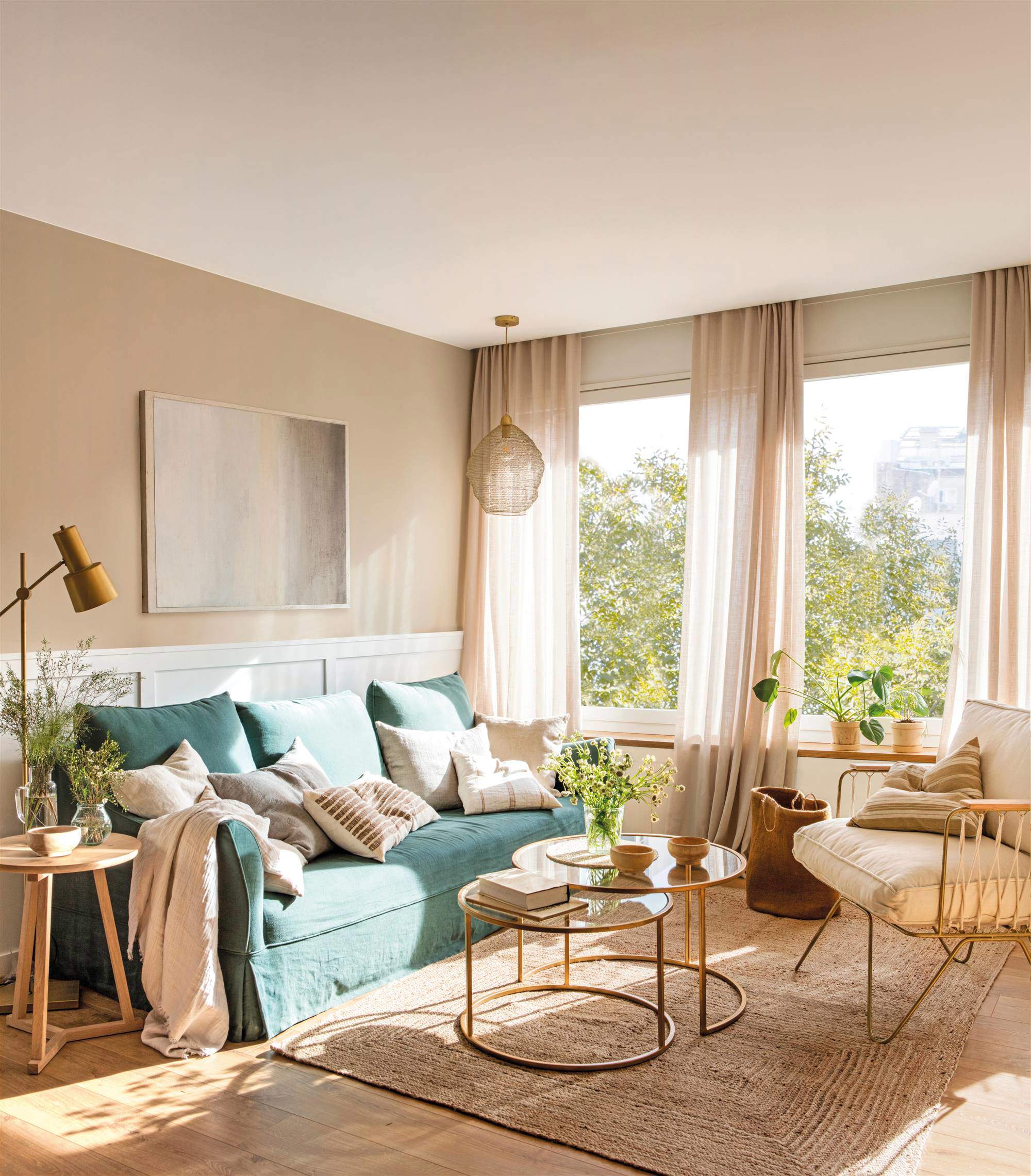 Salón con sofá verde, paredes beige y cortinas vaporosas