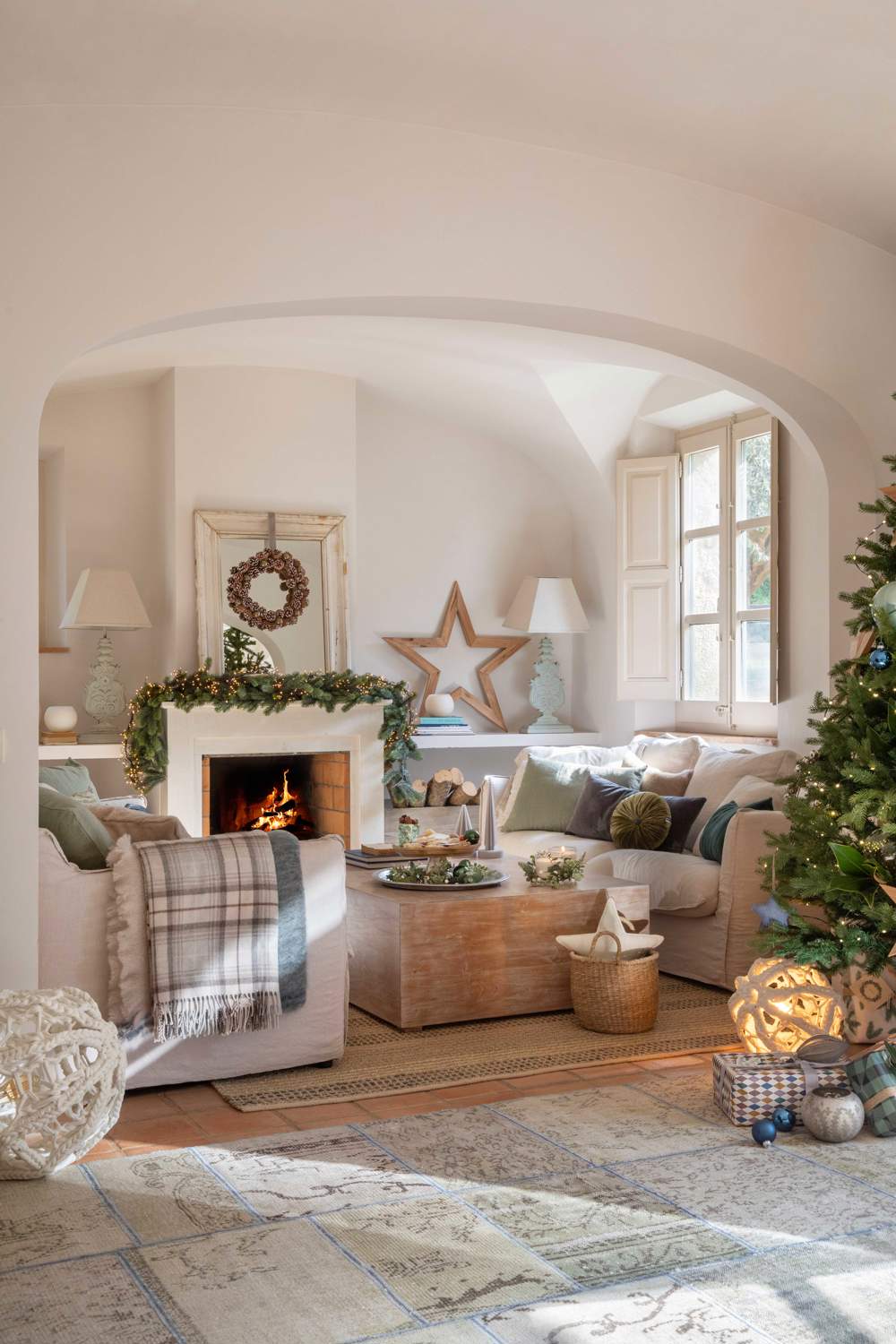 Salón navideño con chimenea decorada, árbol, corona y estrella de madera
