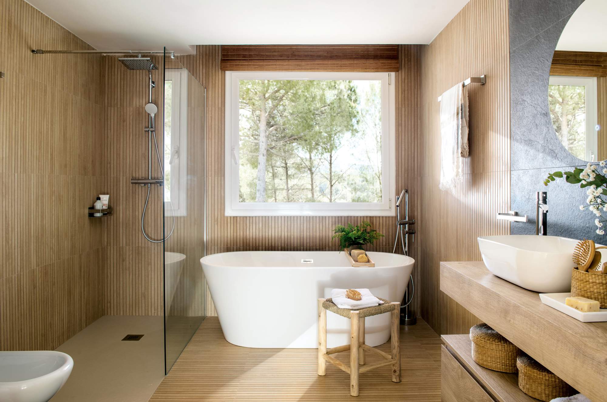 Baño revestido de madera con bañera y ducha.
