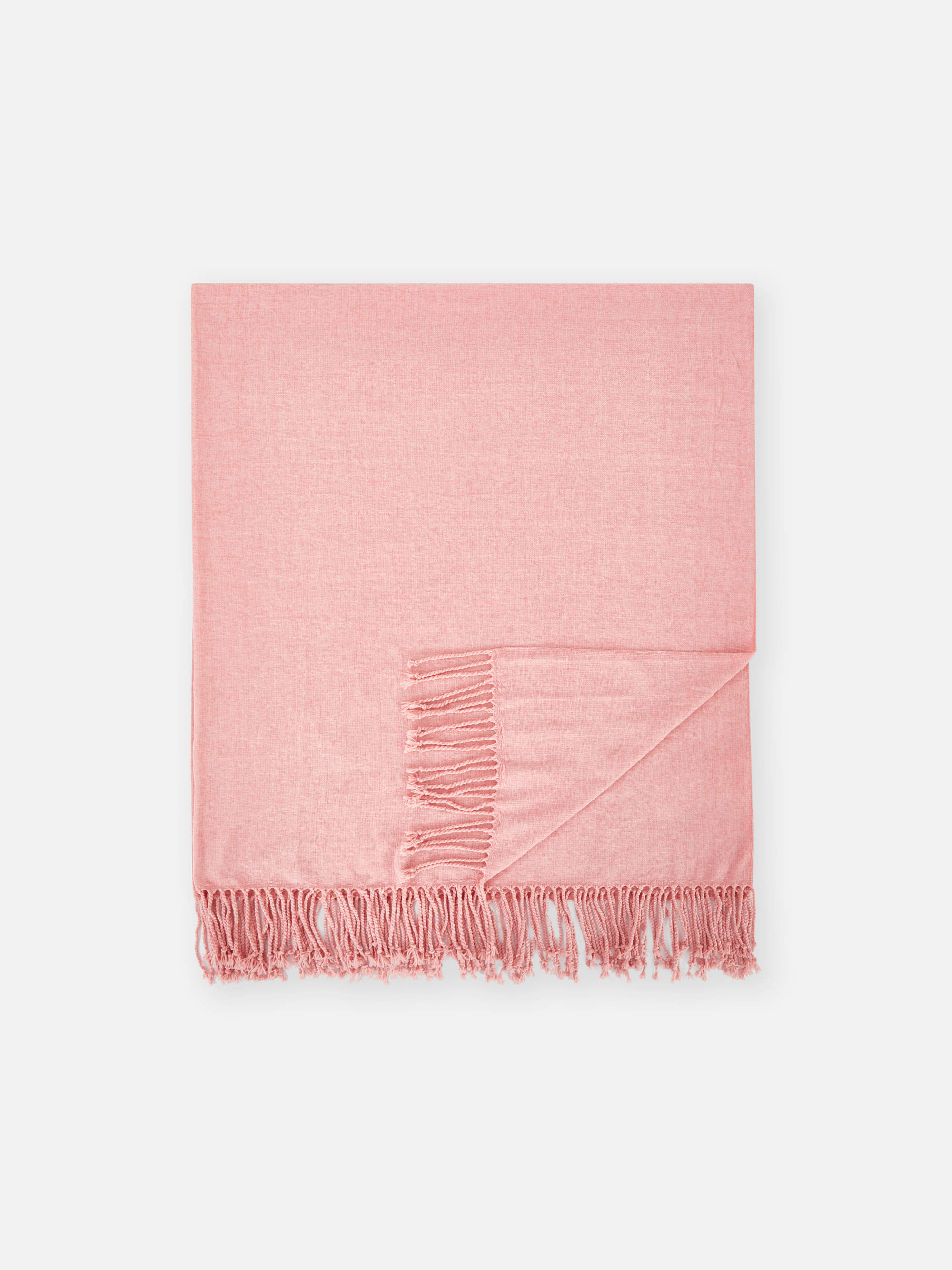Una manta throw rosa de chenilla con flequitos muy decorativa.