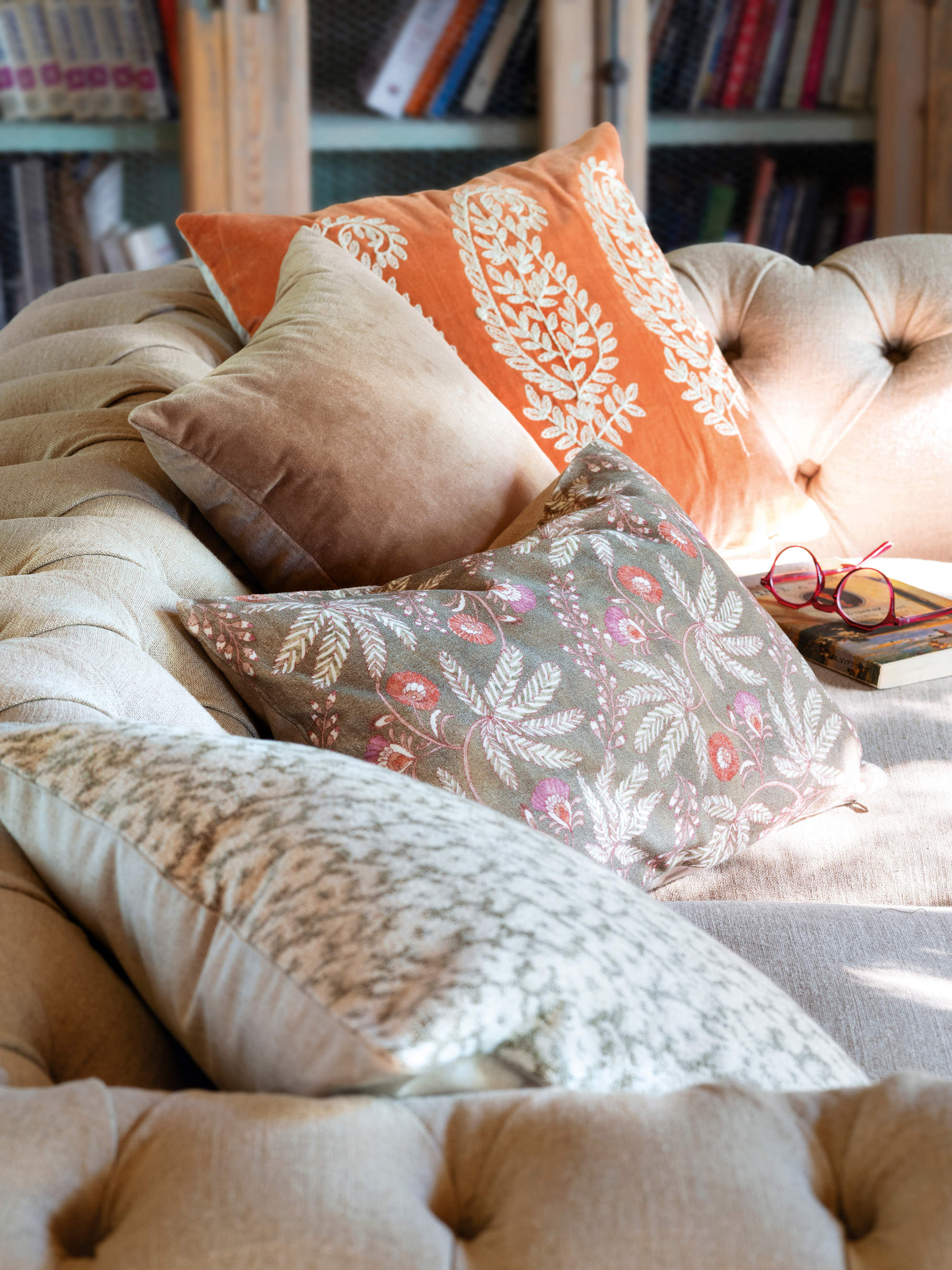 Detalle de cojines bordados y estampados sobre el sofá 