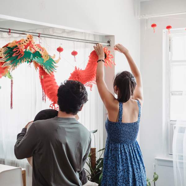 Una familia decorando la casa para el Año nuevo chino