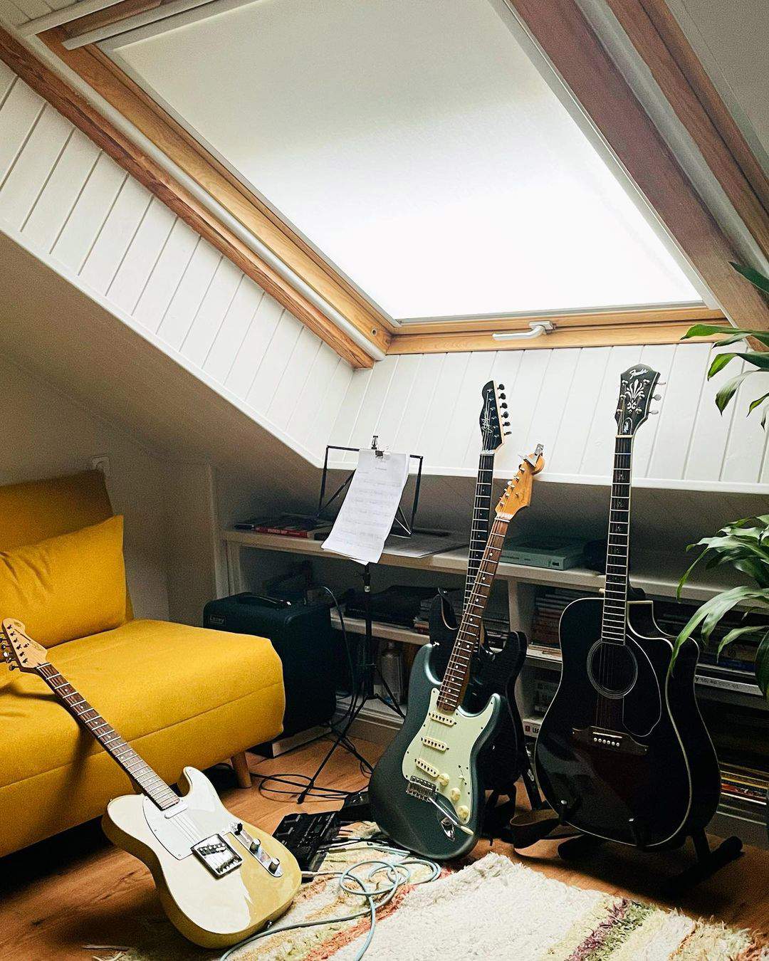 Buhardilla con guitarras y sofá de David Cantero.