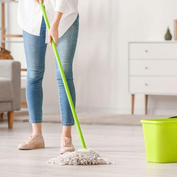 Mujer fregando el suelo de casa