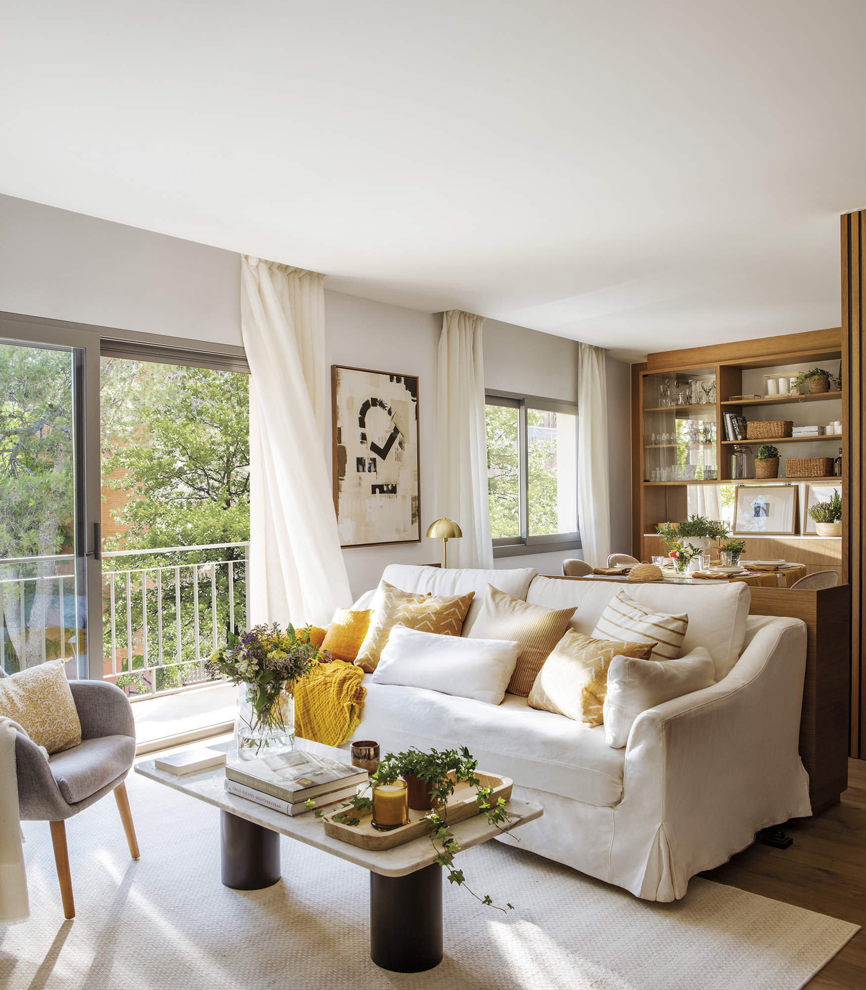 Salon con sofa blanco, ventanales y cuadro abstracto