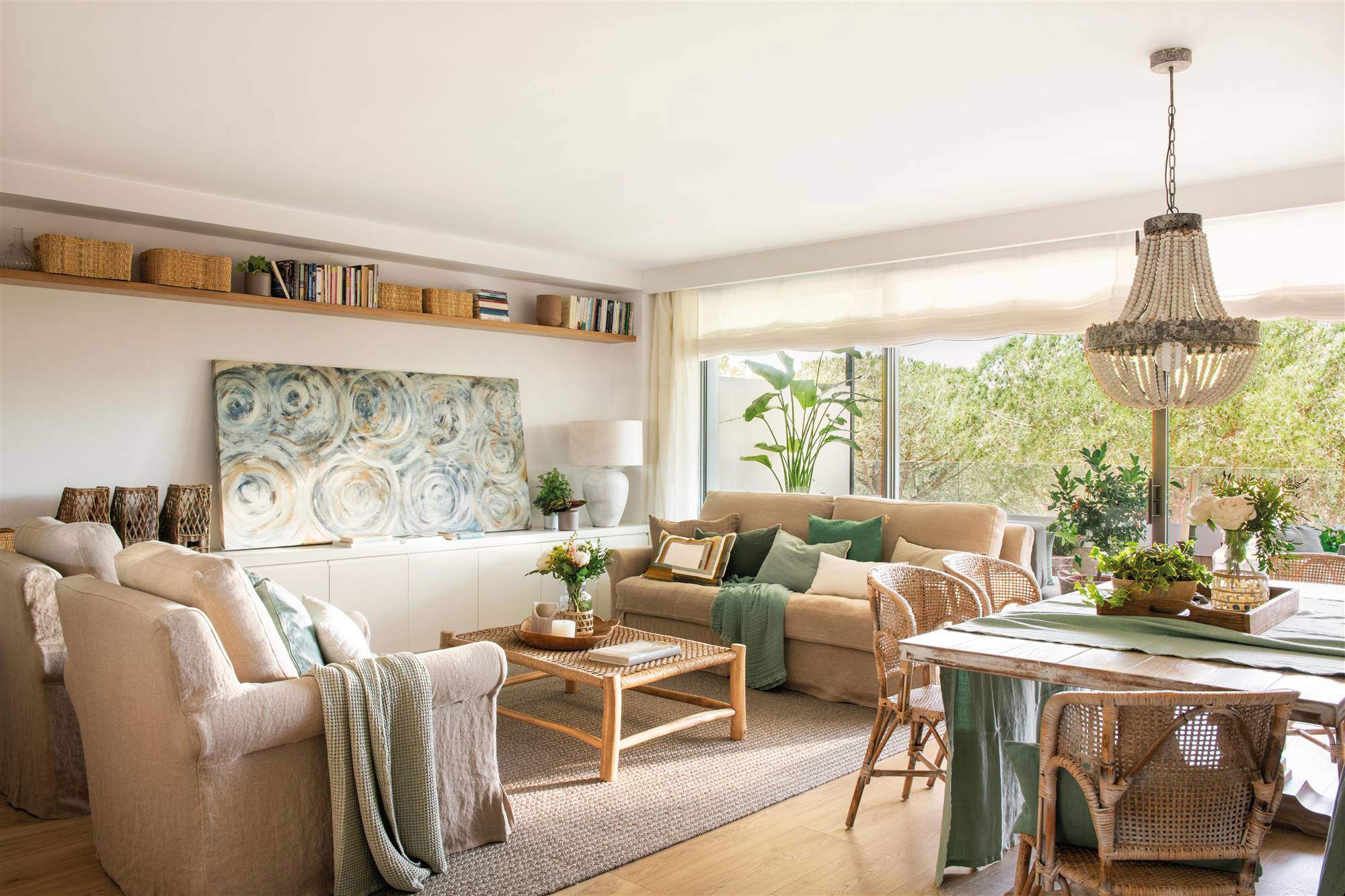Salón decorado en tonos beis y verdes con muebles de madera y fibra.