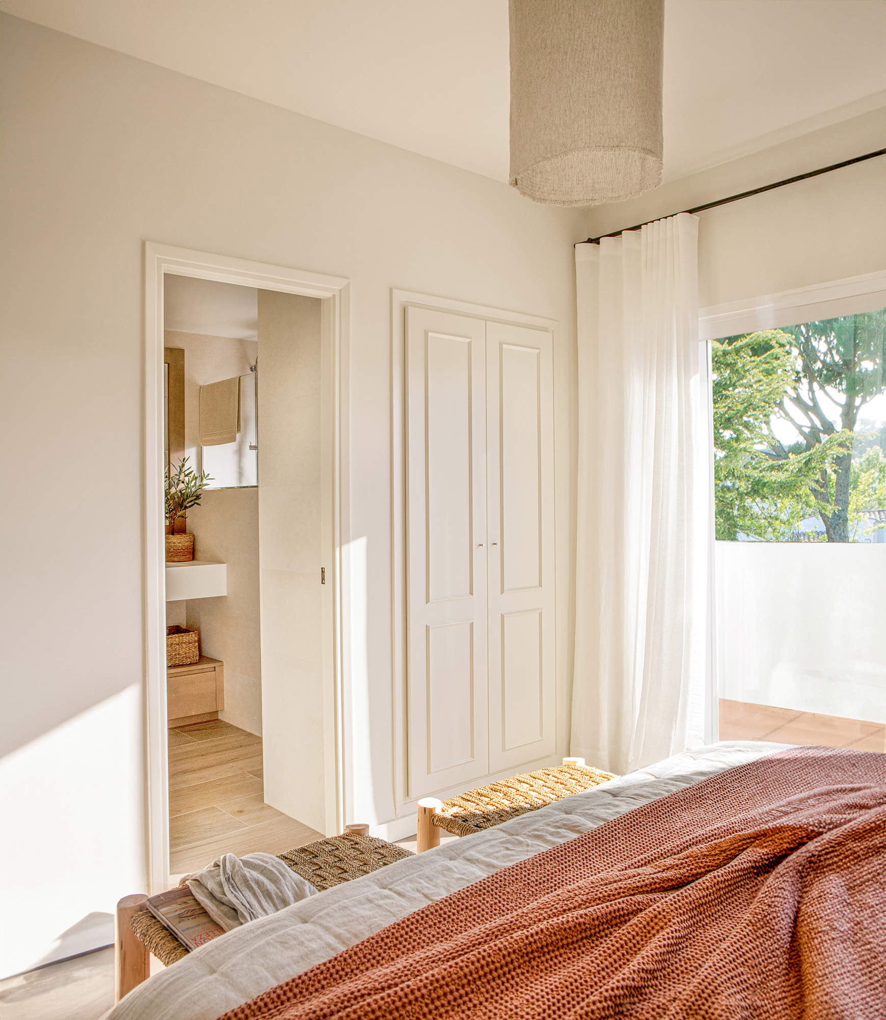 Dormitorio con visillo en la ventana y armario pequeño