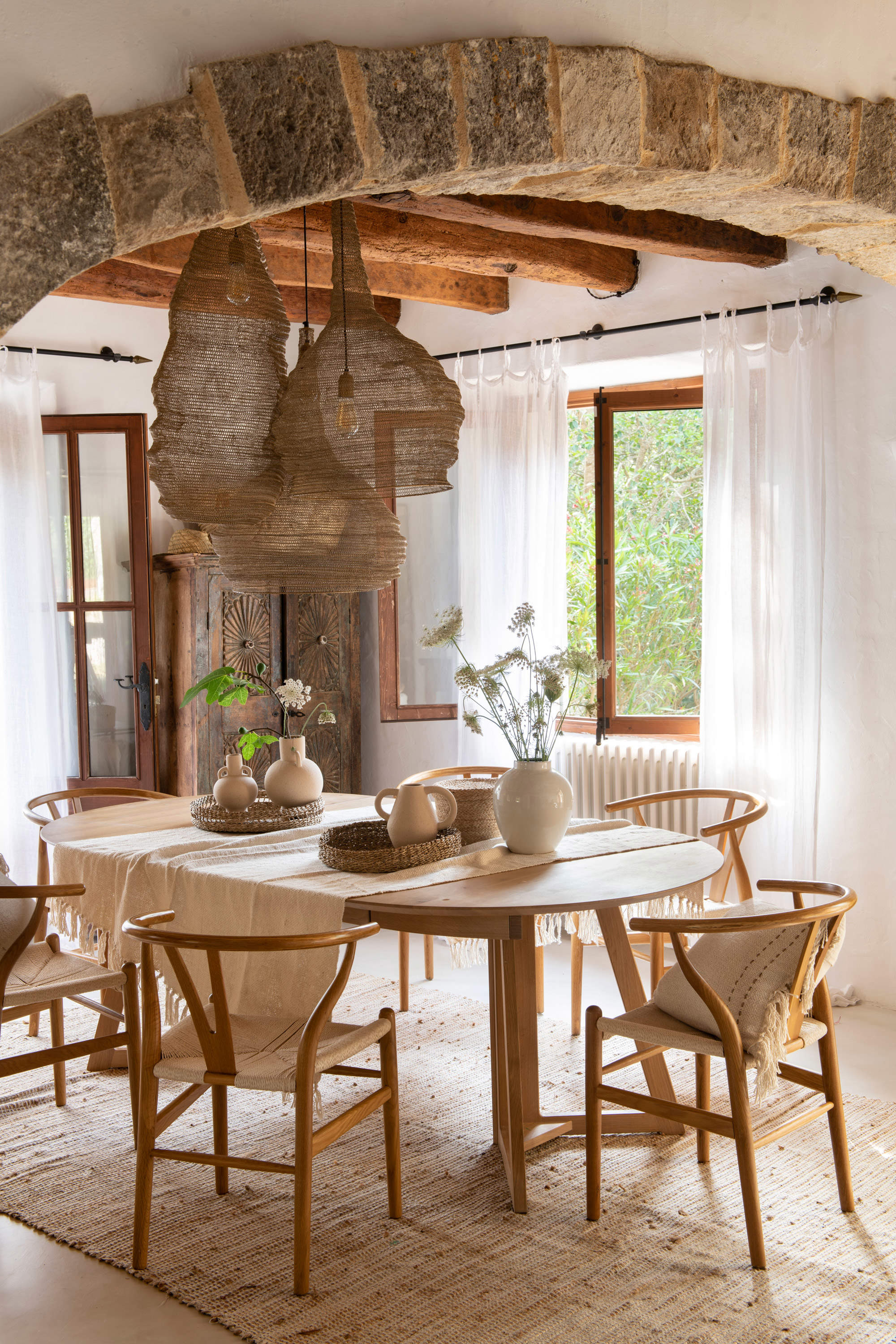 Comedor con muebles de madera y lámparas de techo de formas orgánicas.