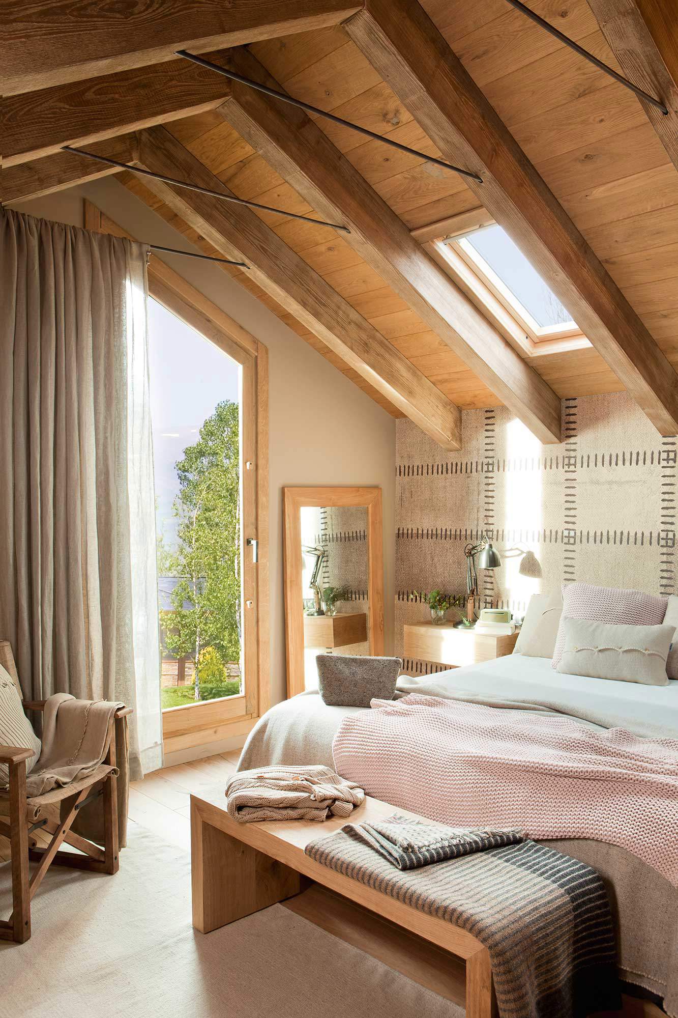 Dormitorio rústico con techo abuhardillado de madera y vigas