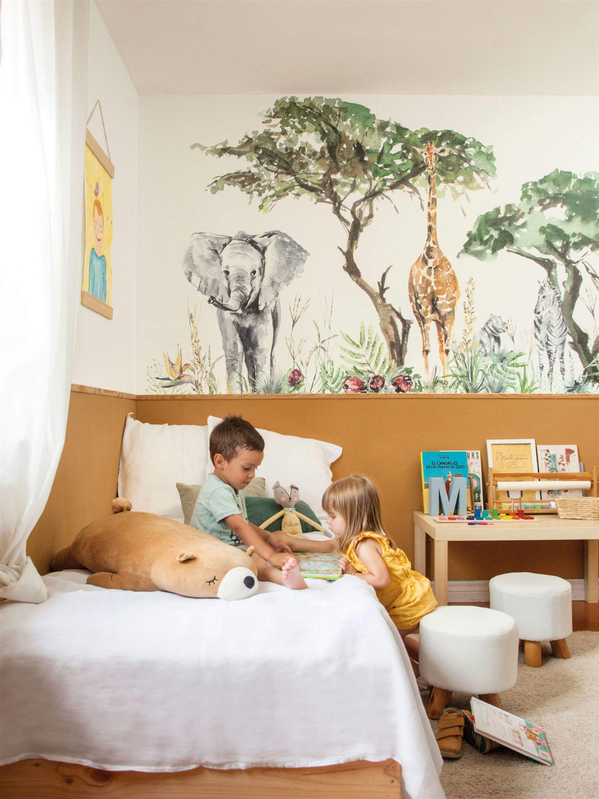 Dormitorio infantil con arrimadero a modo de cabecero y mural en acuarela