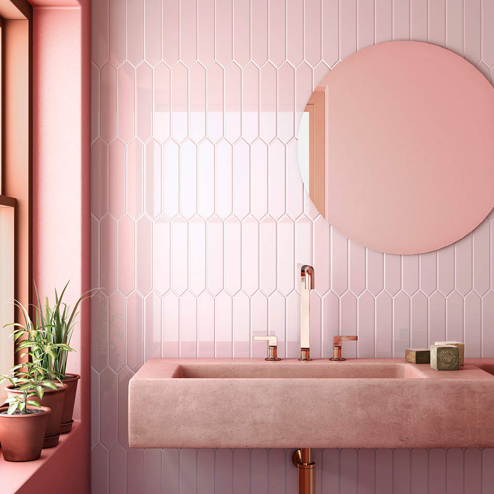 Baño con pared del lavabo con azulejos de color rosa.
