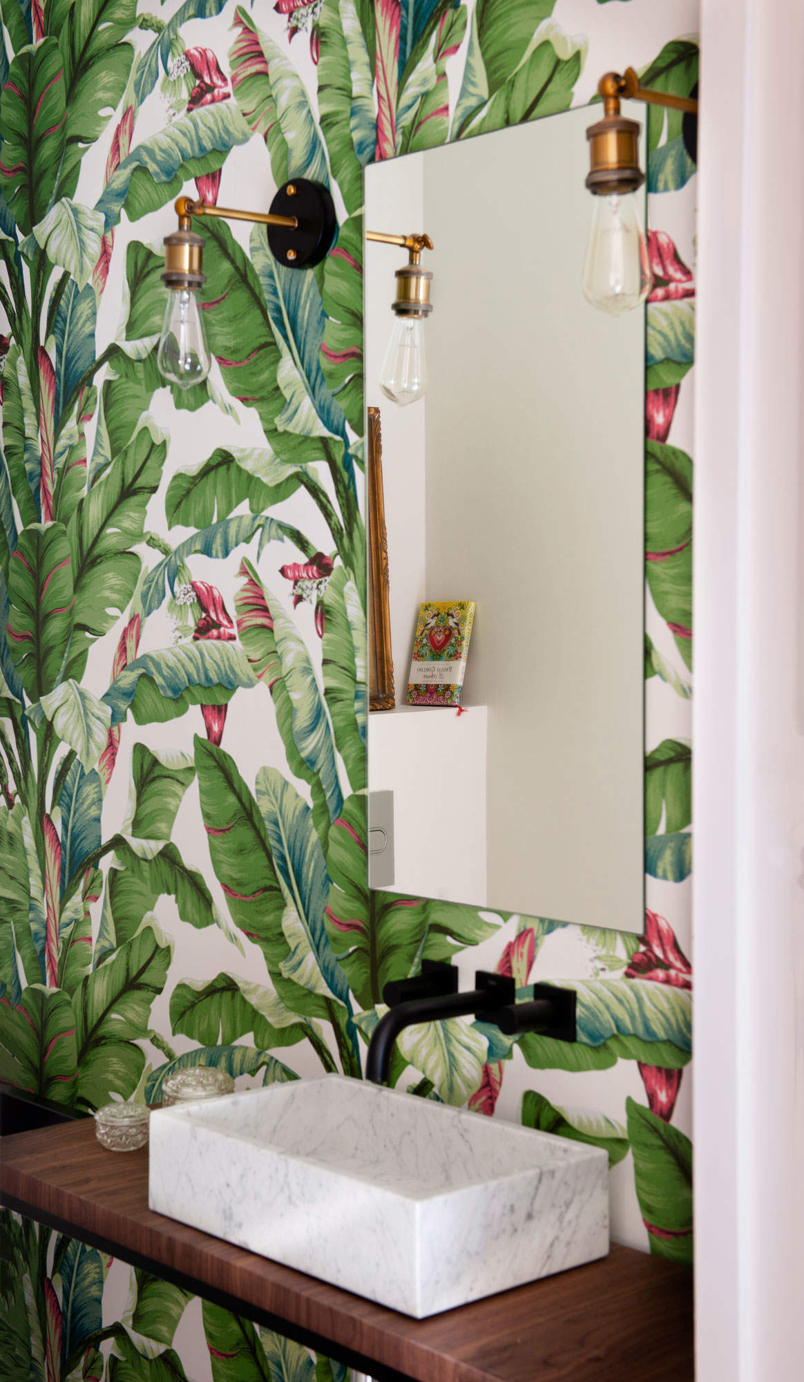 Cuarto de baño con papel pintado tropical.