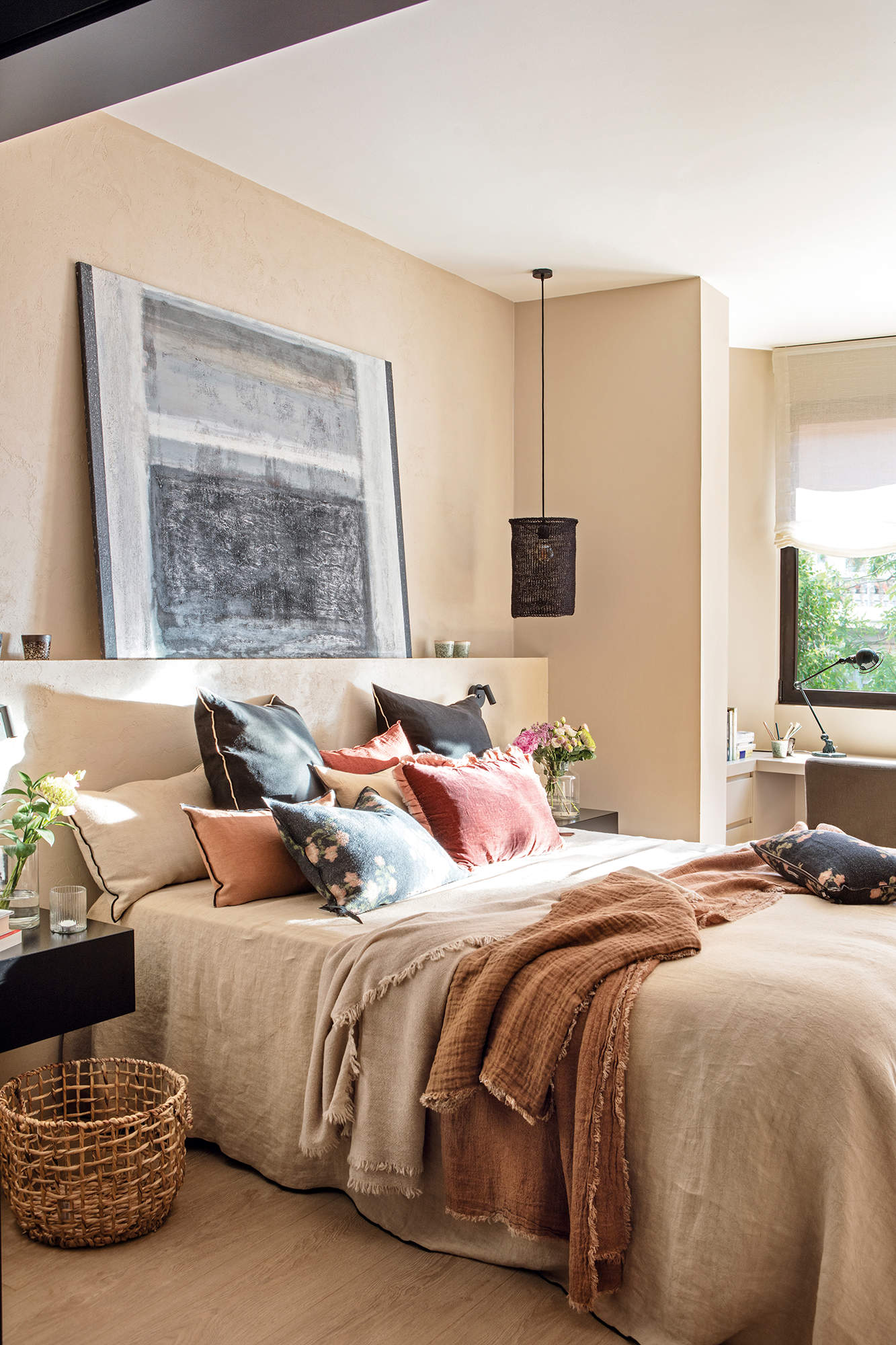 Dormitorio con cabecero de obra y cuadro en tonos grises. 