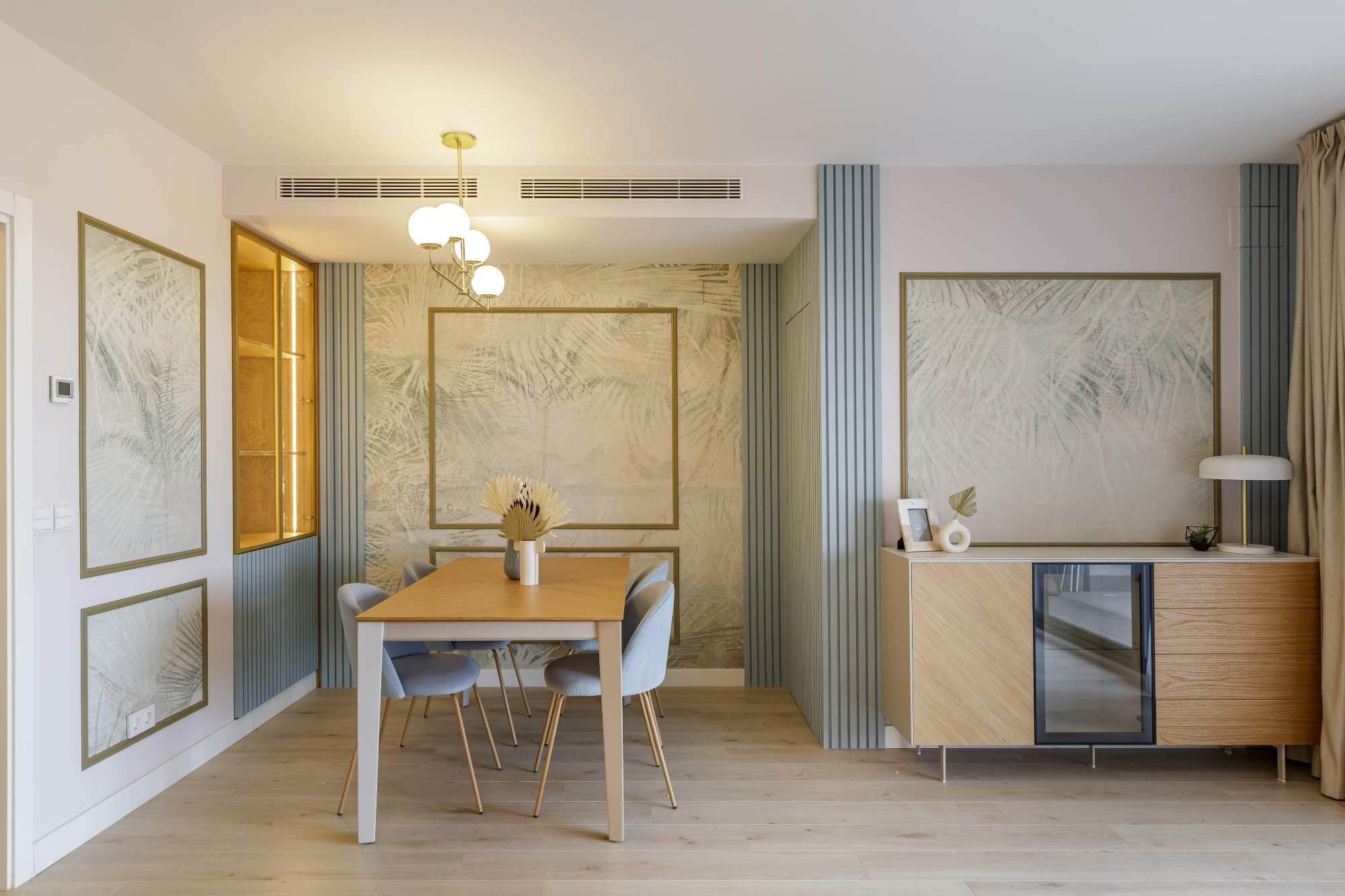 Un salón comedor con zona office en tonos azulados y con madera.
