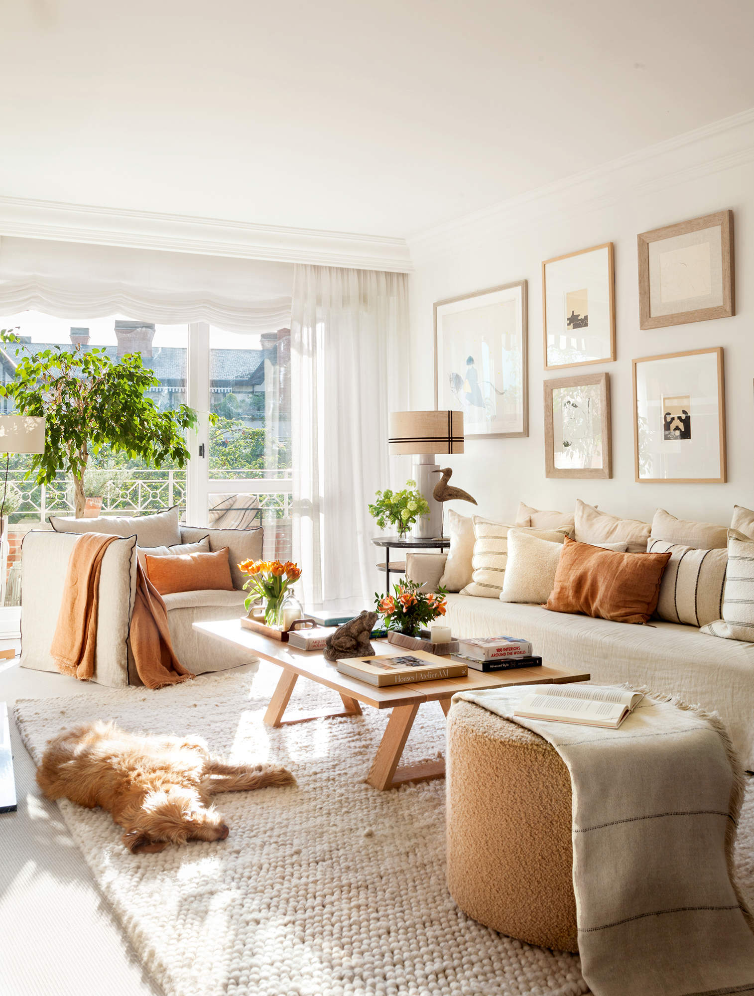 Salón clásico con sofá de lino desenfundable, mesa de madera, cuadros y lámpara moderna.
